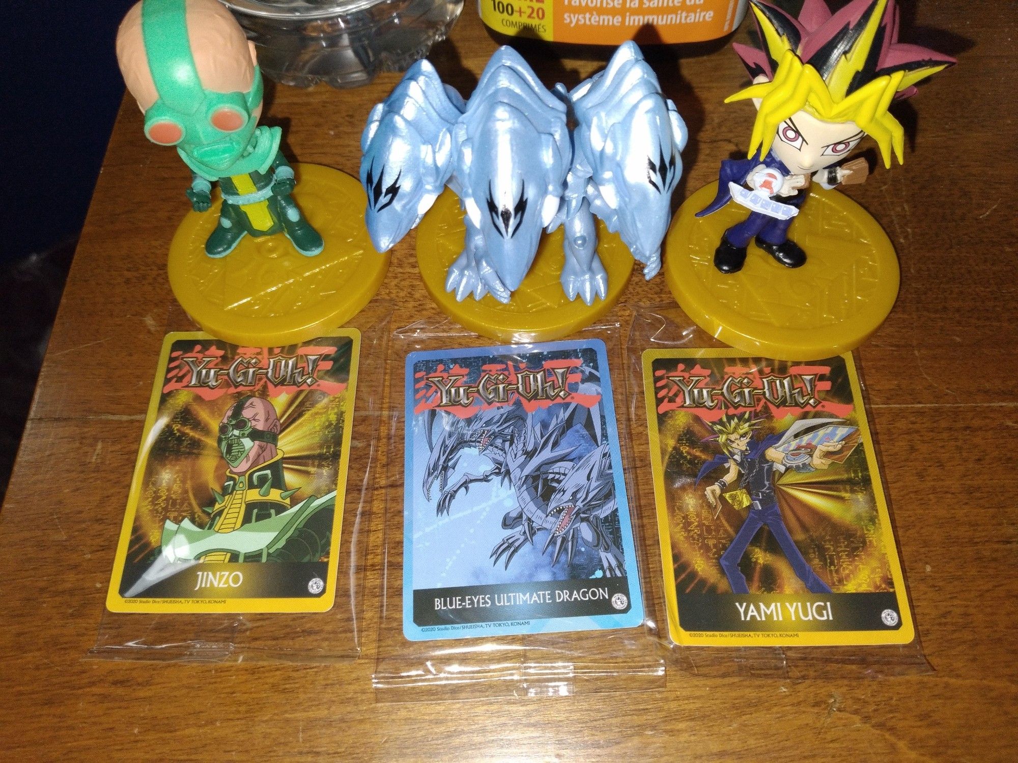 A close up/above shot of the mini yugioh figs n their art cards, which are as; Jinzo, Blue-Eyes Ultimate Dragon and Yami Yugi.