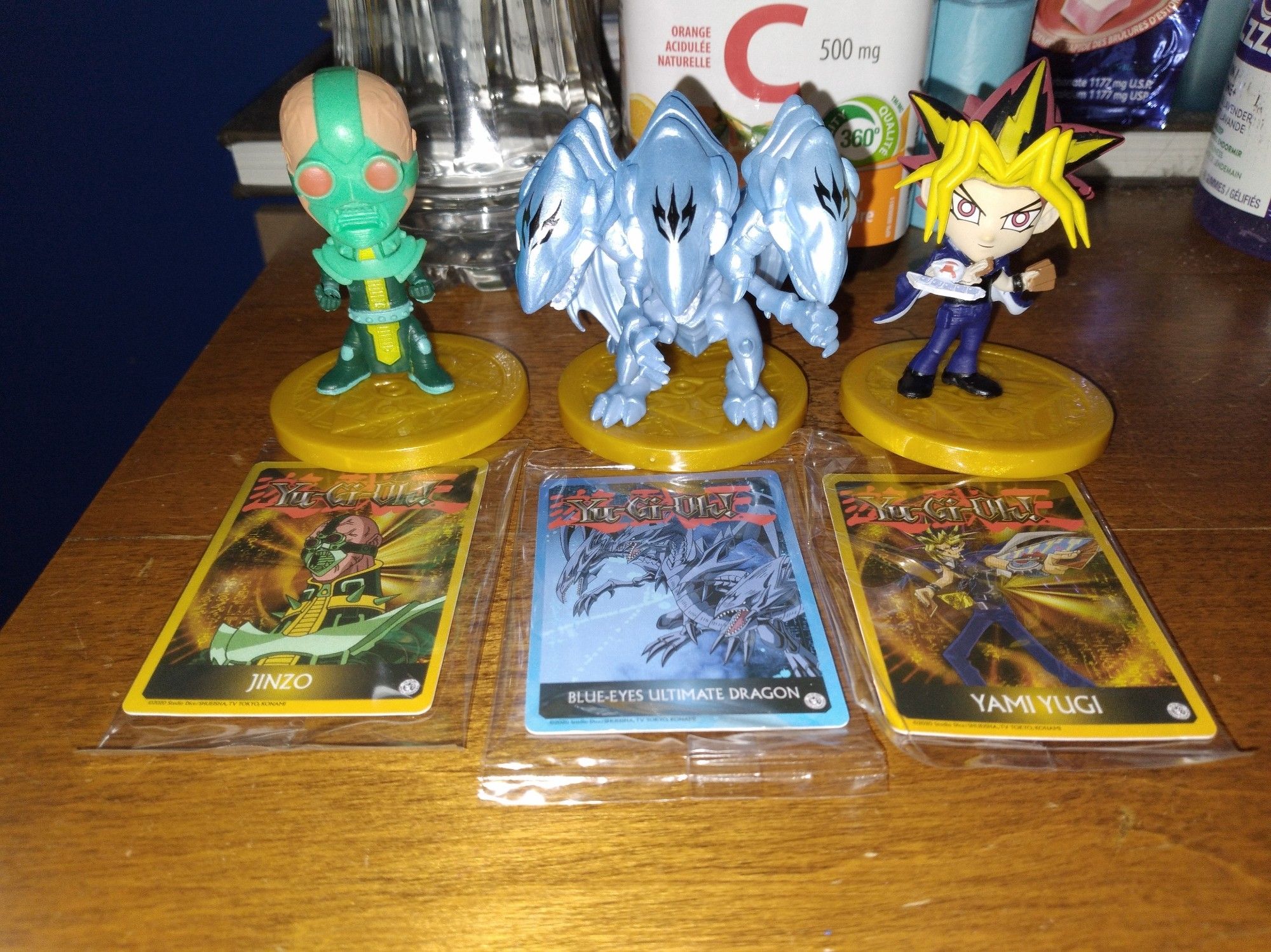 The mini yugiog figs fromt left to right; Jinzo with mini card out front of it, the middle fig is Blue-Eyes Ultimate Dragon with its mini card info in front of it, the last n right fig is of Yami Yugi n his art card infront as well.