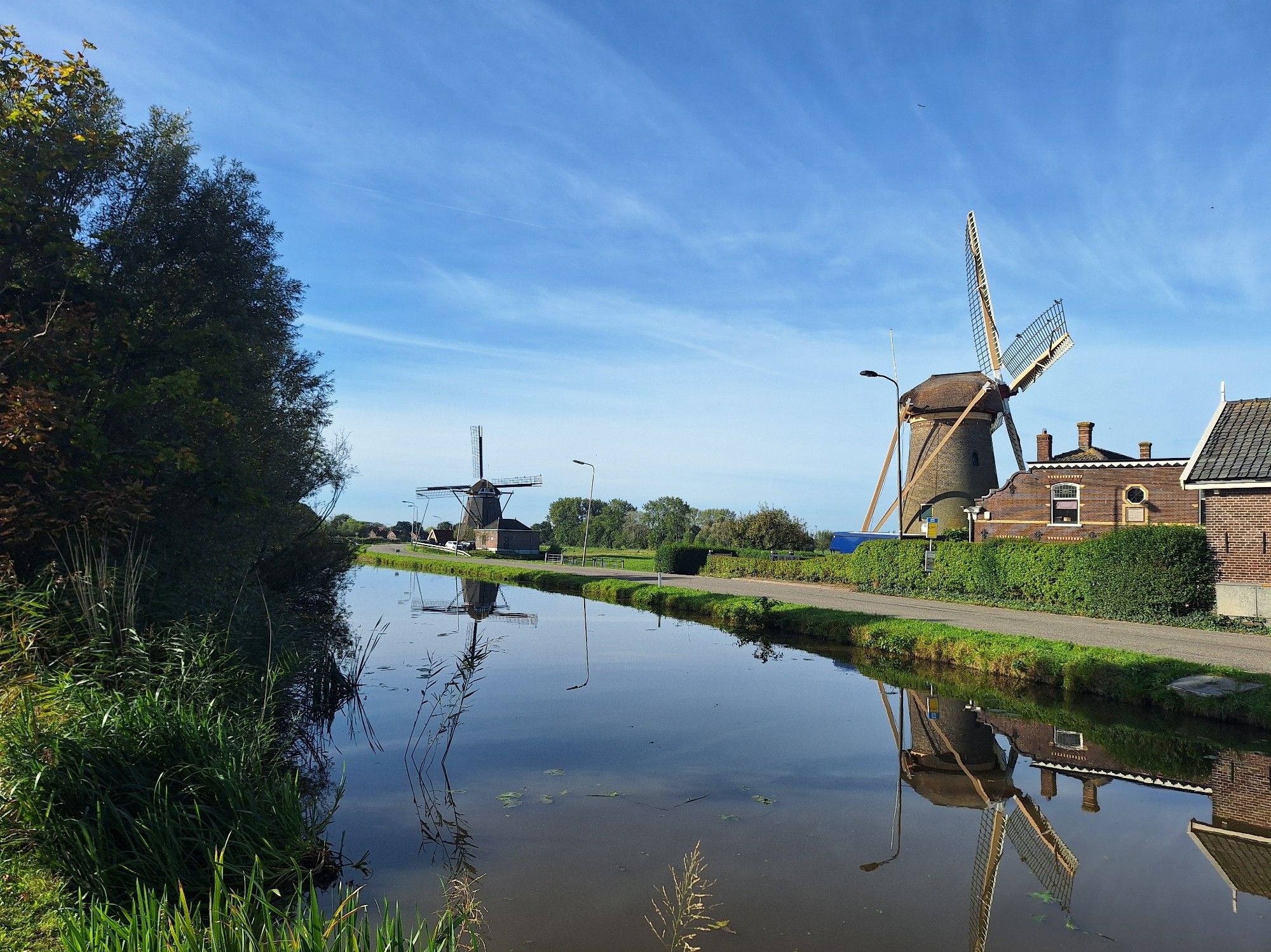 Foto genomen vanaf de Commandeurskade in Maasland met op de voorgrond Molen 'De Drie Lelies' en de Dijkmolen.