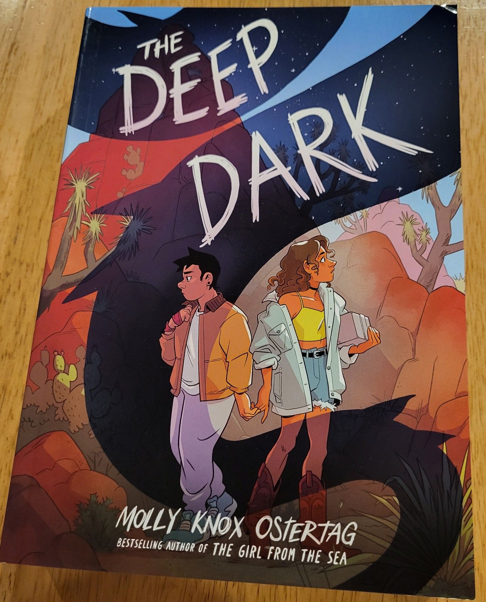 Photo of the cover to the graphic novel The Deep Dark by Molly Knox Ostertag, sitting on my dining table.