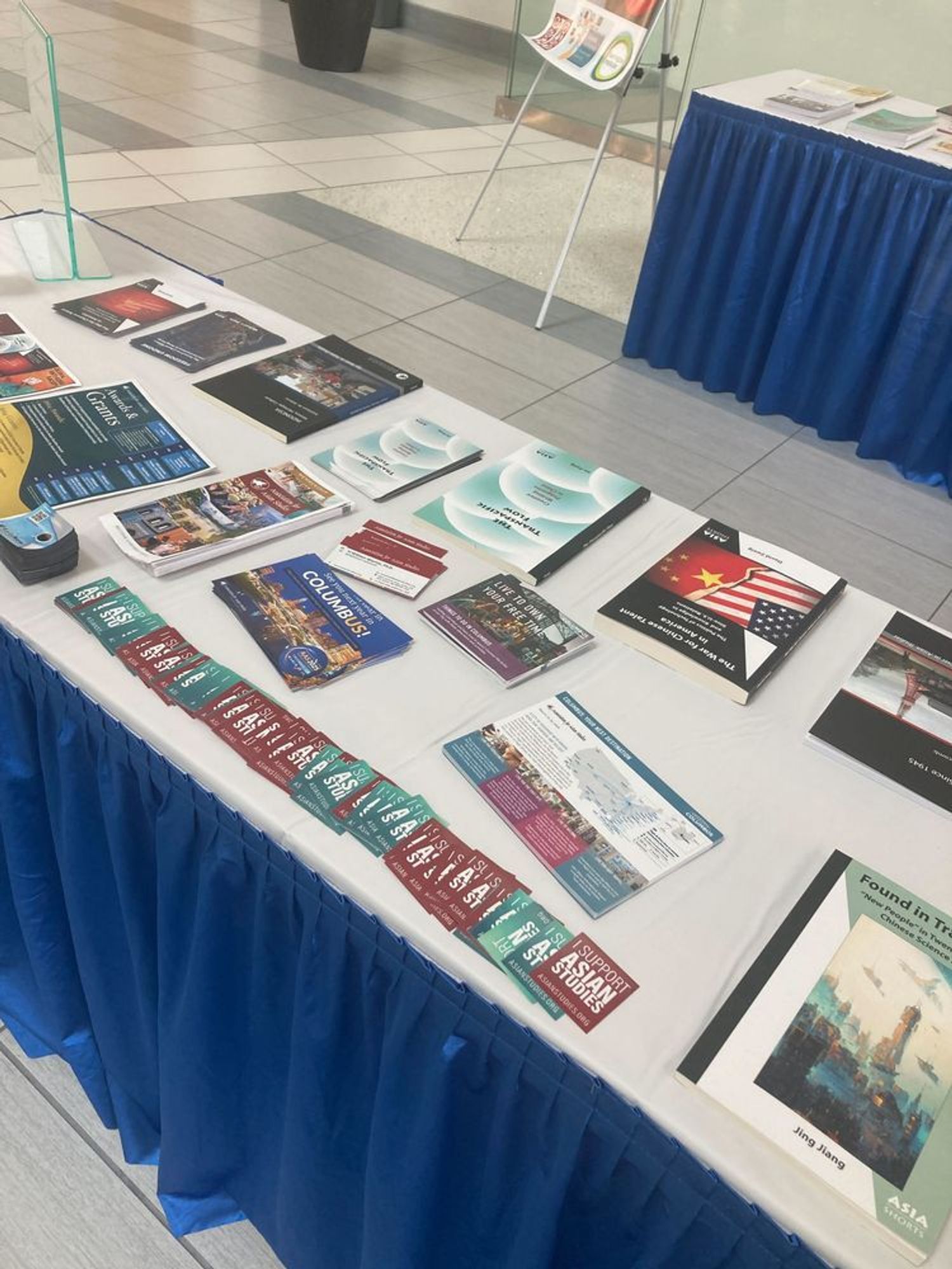 A photo of an exhibit table, its top displaying an array of AAS publications, postcards, and promotional materials.