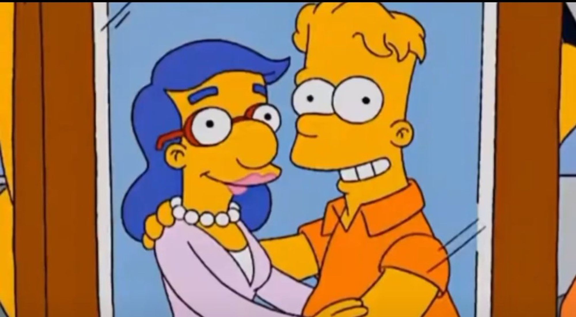 A screen shot from the Simpsons episode, "Double, Double, Boy in Trouble," Showing an older Bart Simpson embracing their significant other, who appears to be a femme-presenting Milhouse Van Houten. While this is just "crypto" enough that producers can spin this many ways, many are feeling this is a trans Milhouse with Bart as a supportive husband. They both have never looked happier.