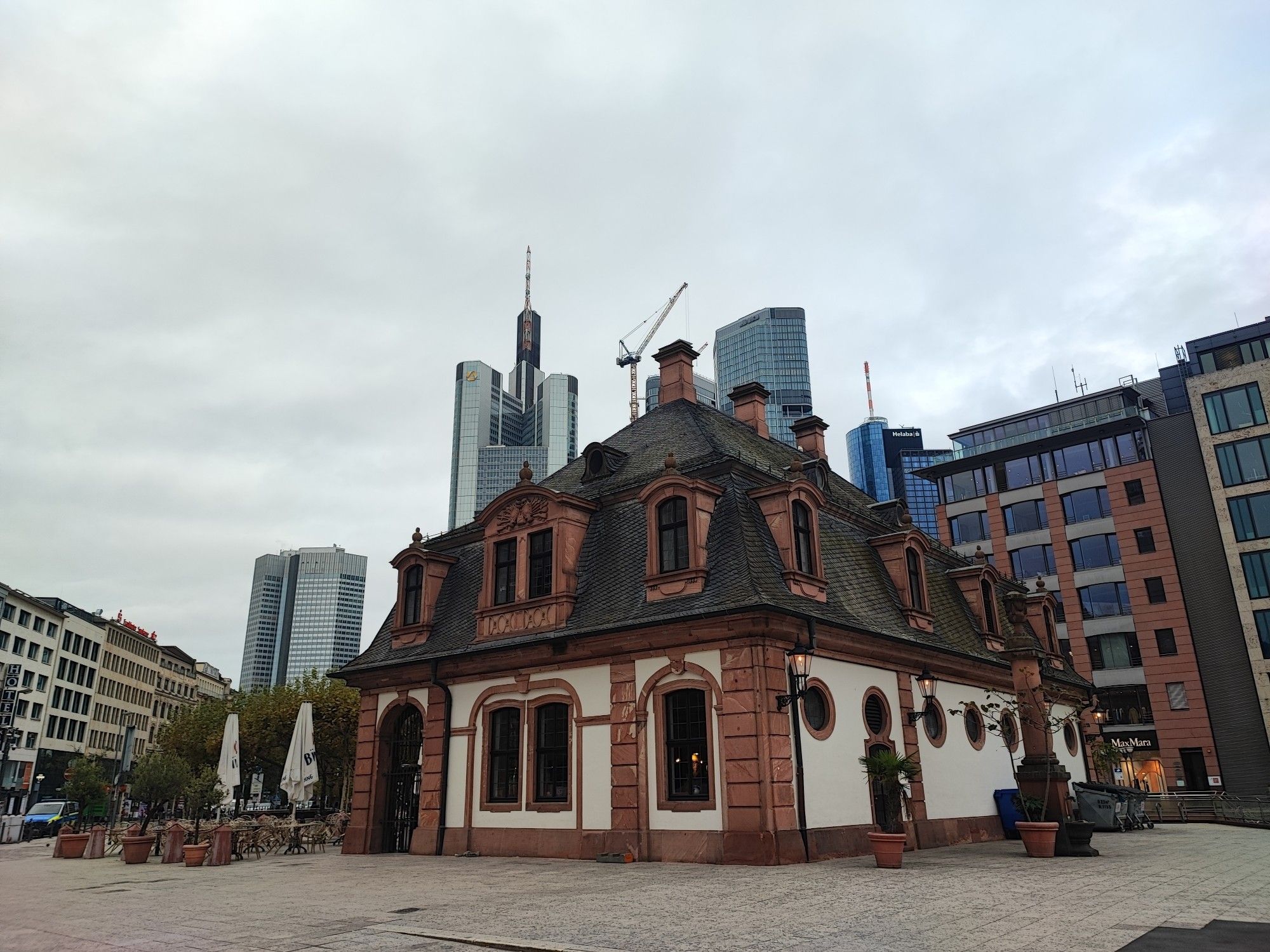 Im Vordergrund ein altes Gebäude wo ein Restaurant drin ist. Im Hintergrund einige der Bankentürme in Frankfurt.