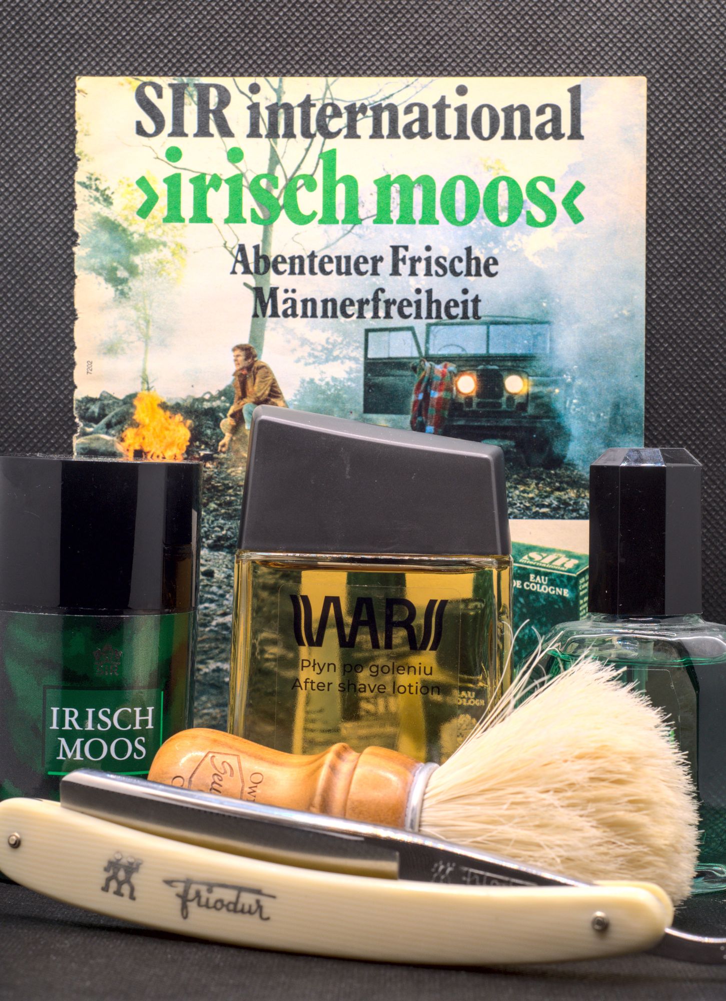 A bottle of WARS splash surrounded by Irisch Moos art and software, with a SOC boar brush and a chonky Frio 17