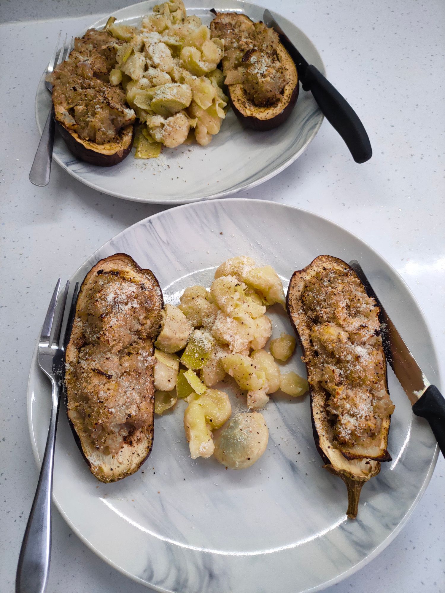 Aubergine (eggplant in US) filled with fennel, red onion and garlic, baked in the oven. Served with cauliflower gnocchi and artichoke hearts. Parmesan cheese sprinkled on everything.