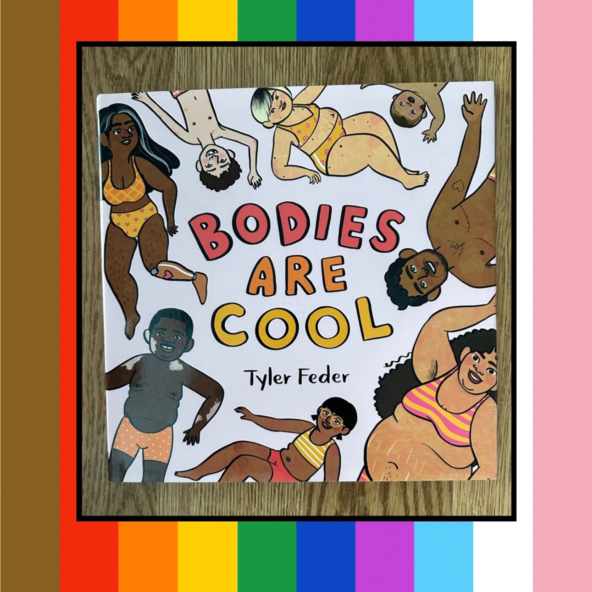 Rainbow striped graphic with a picture of a picture book called BODIES ARE COOL by Tyler Feder on it. The cover shows different shaped bodies with different skin tones in underwear surrounding the title in the middle.