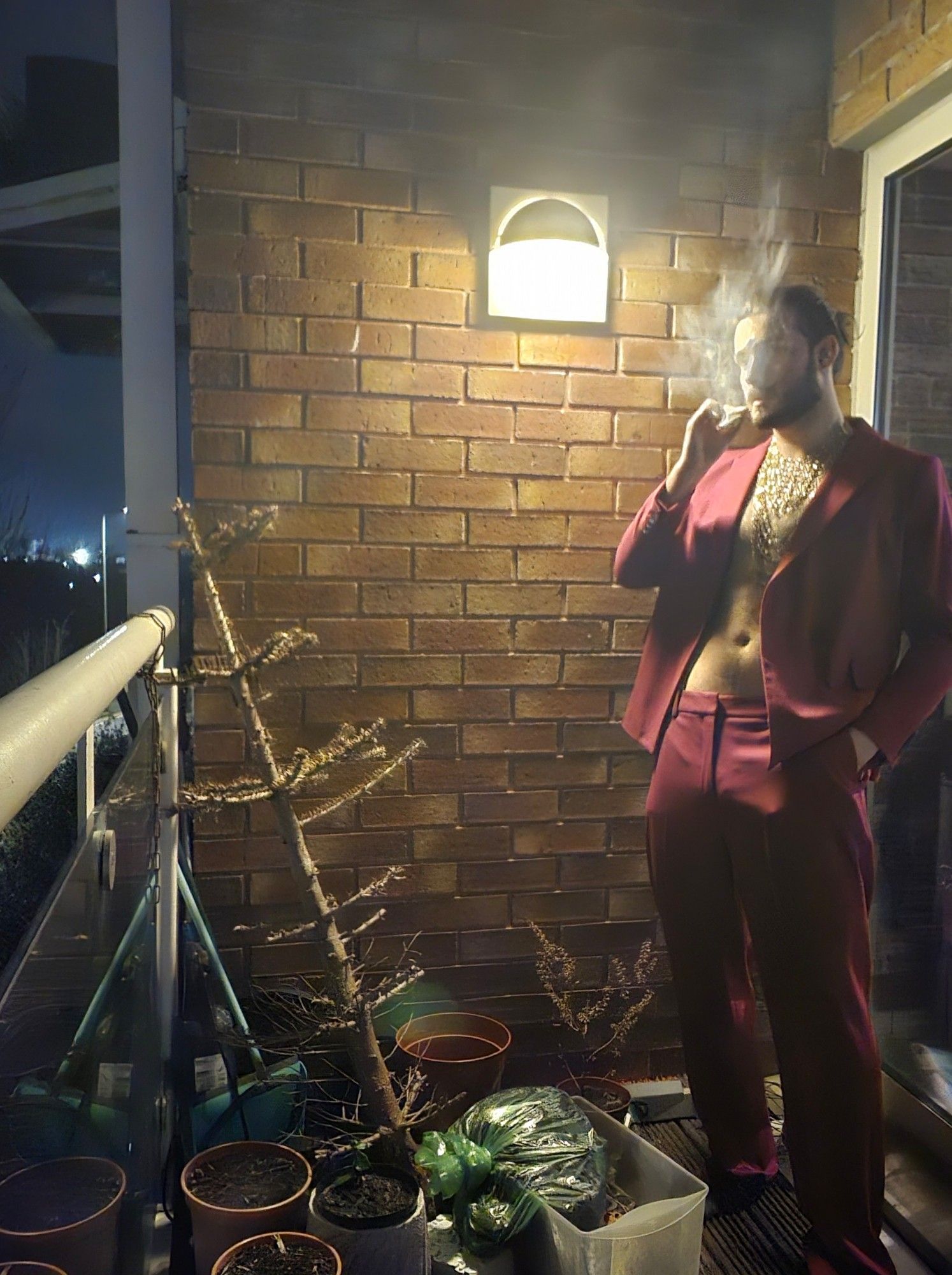 Low light photograph of me smoking on my balcony in a purple power suit