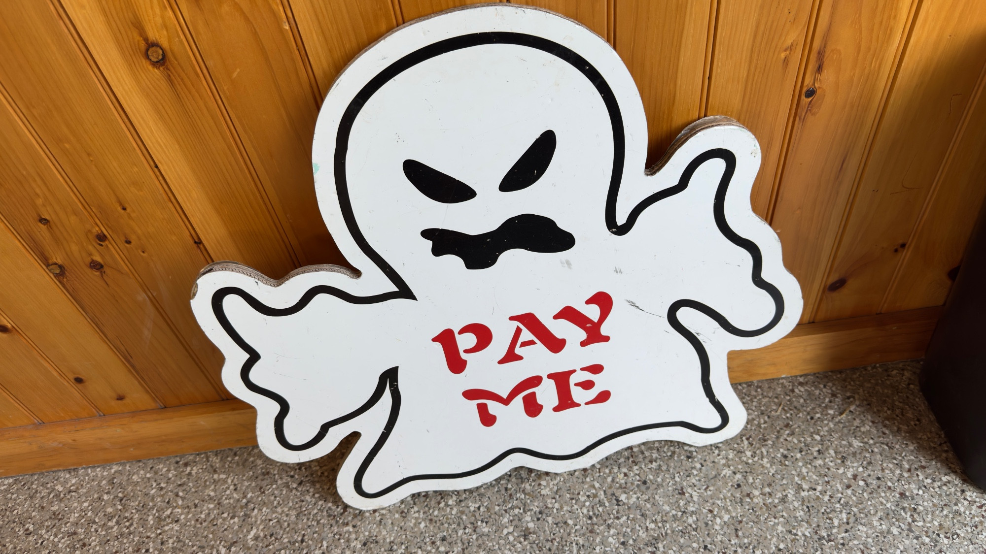 a spooky cartoon ghost that says PAY ME in a spooky font