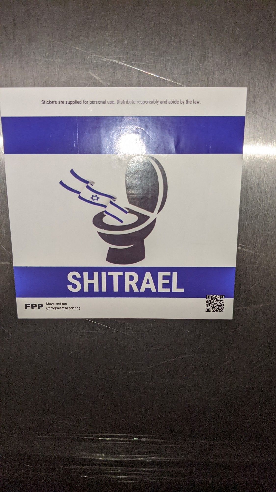 A blue and white stripe sticker, like a flag but with a toilet bowl instead of some bloke's star. The legend reads SHITRAEL.