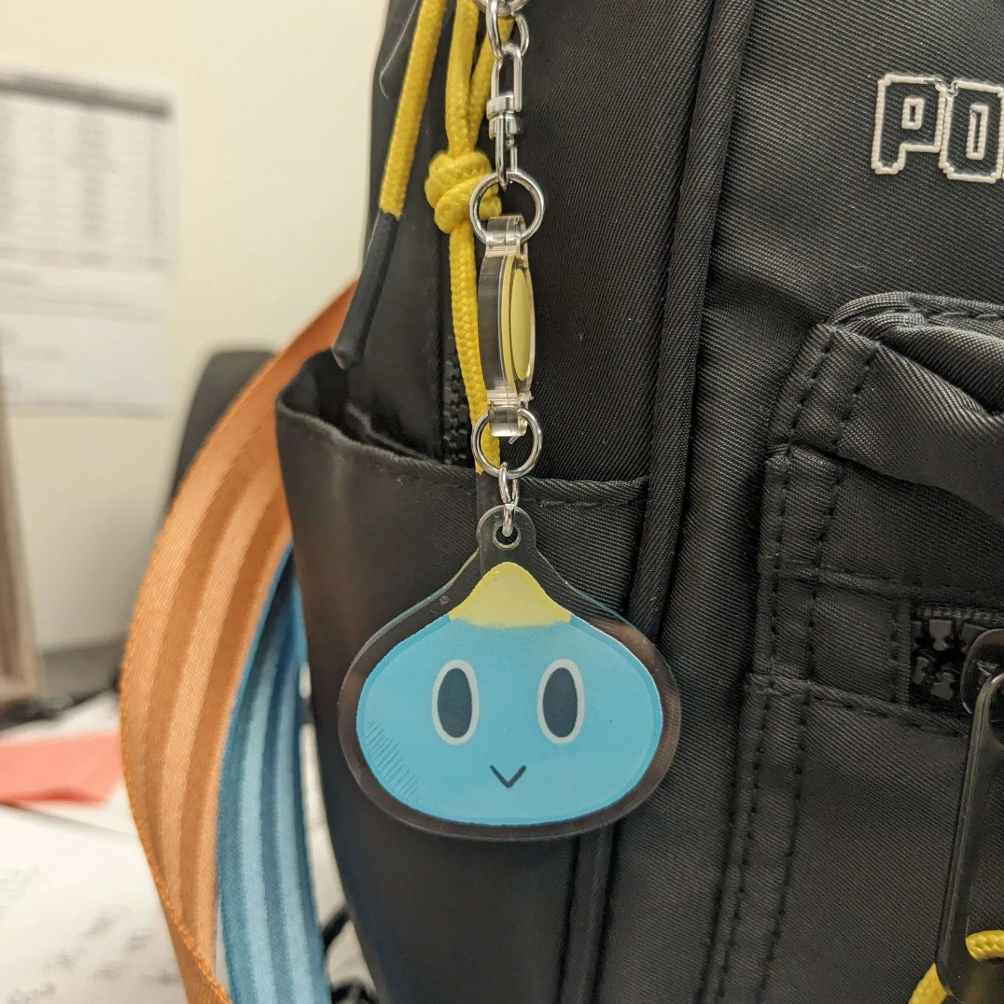 A photo of a bag featuring keychain of the Neutral Chao from the Sonic the Hedgehog series