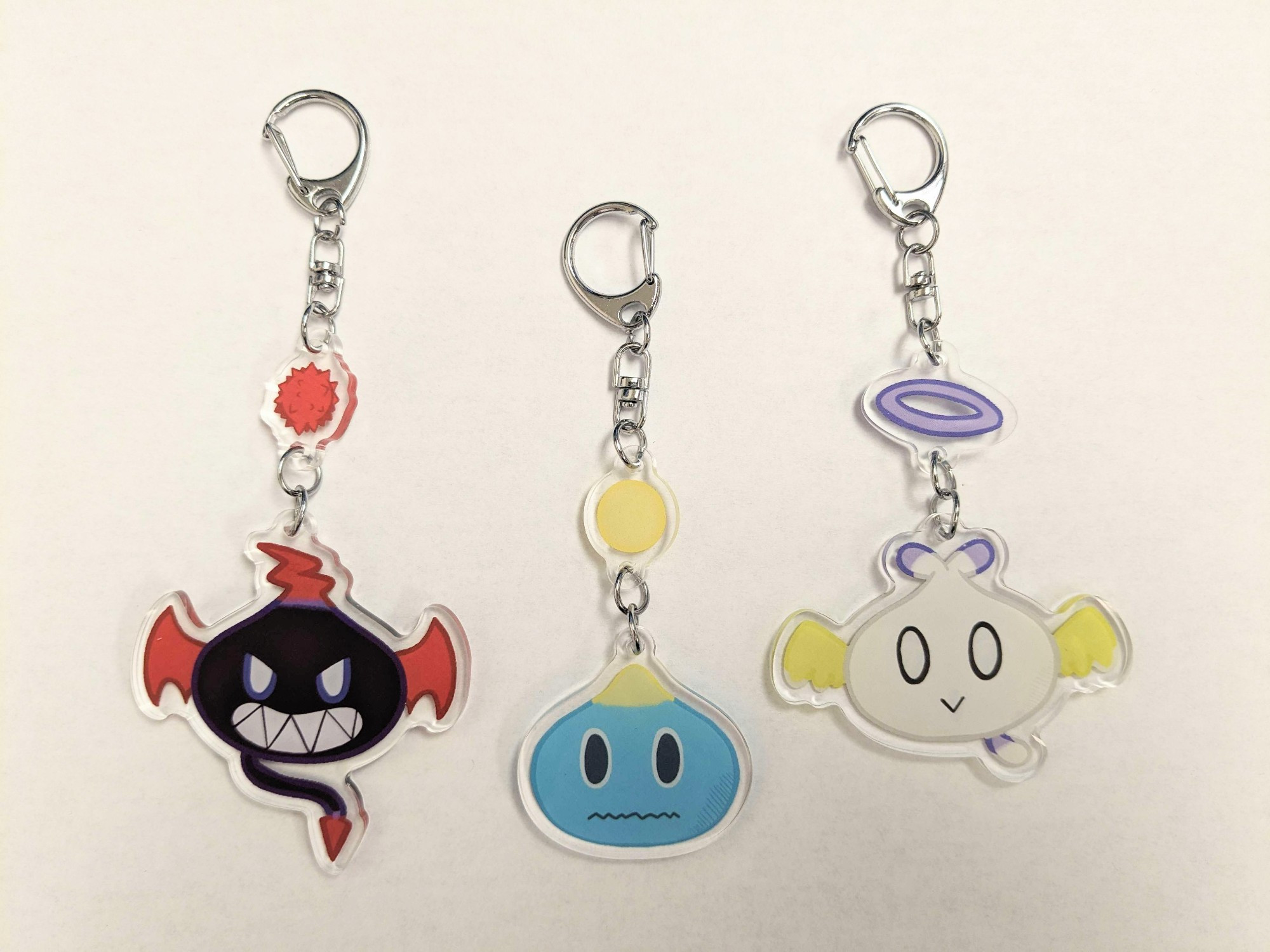 A photo of keychains of the Neutral Chao, Dark Chao, and Hero Chao from the Sonic the Hedgehog series