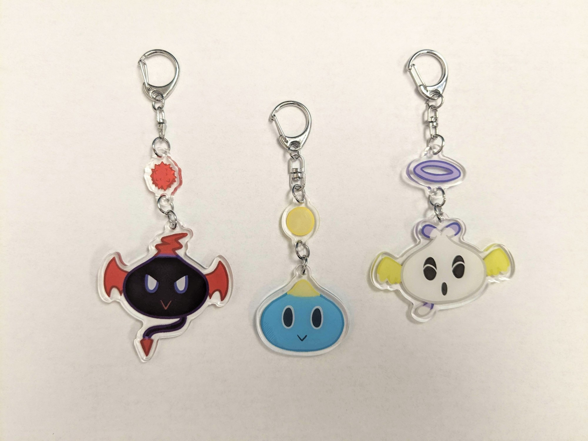 A photo of keychains of the Neutral Chao, Dark Chao, and Hero Chao from the Sonic the Hedgehog series