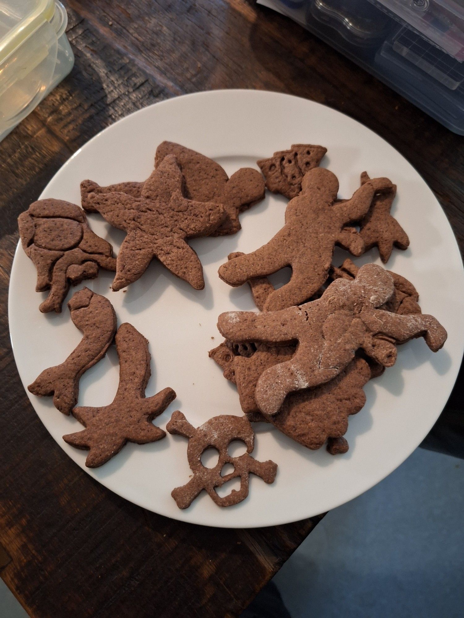 Fertig gebackene Kekse auf einem Teller, unter anderem in der Form von Totenkopf, Meerjungfrau, Seestern, Zombies, Palmen und Weihnachtsbäumen.