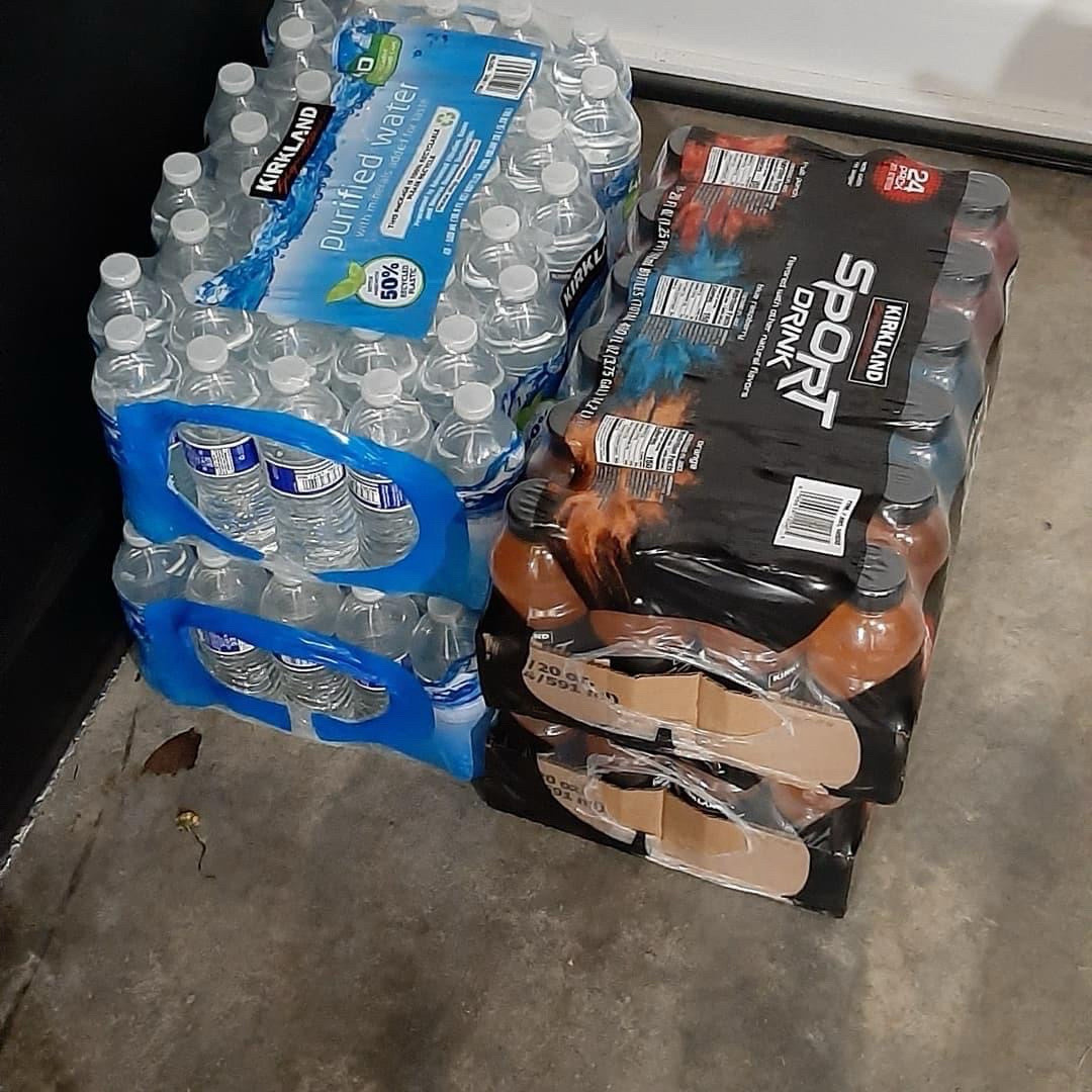 And shows two cases of waters and two cases of sports drinks Sitting on the floor of a garage