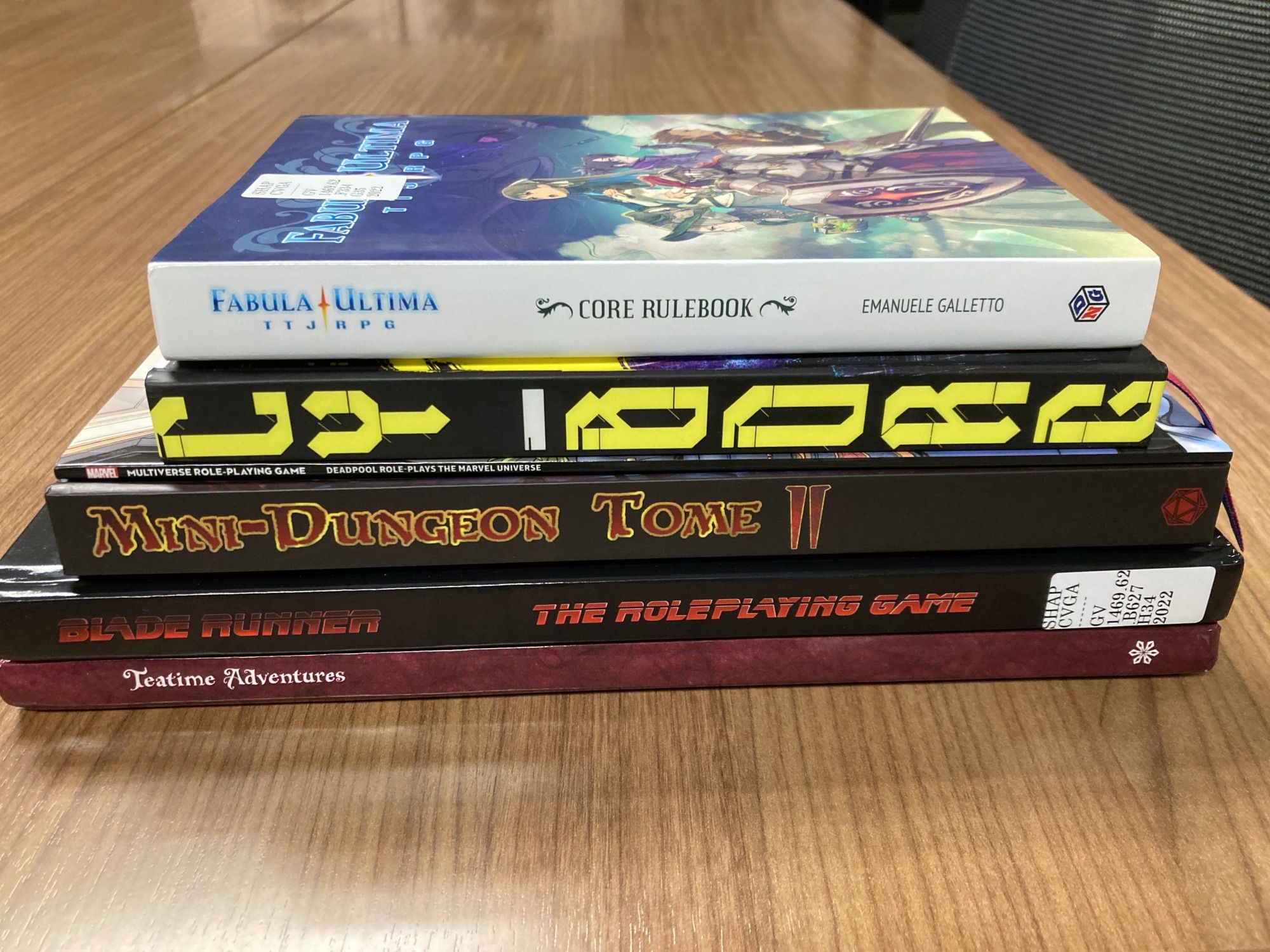 Spines of the books mentioned in the post, lying on a faux woodgrain table.