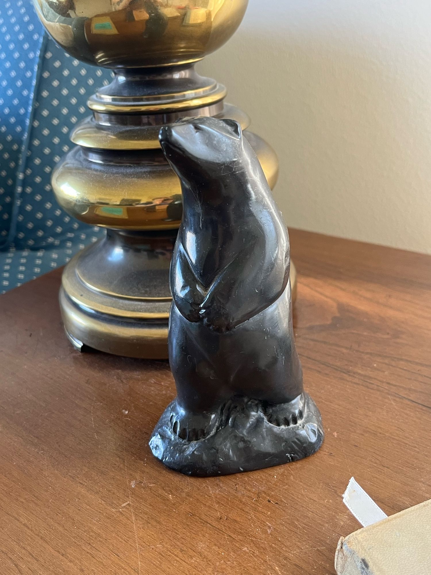 a carved bear of dark smooth material, standing up.