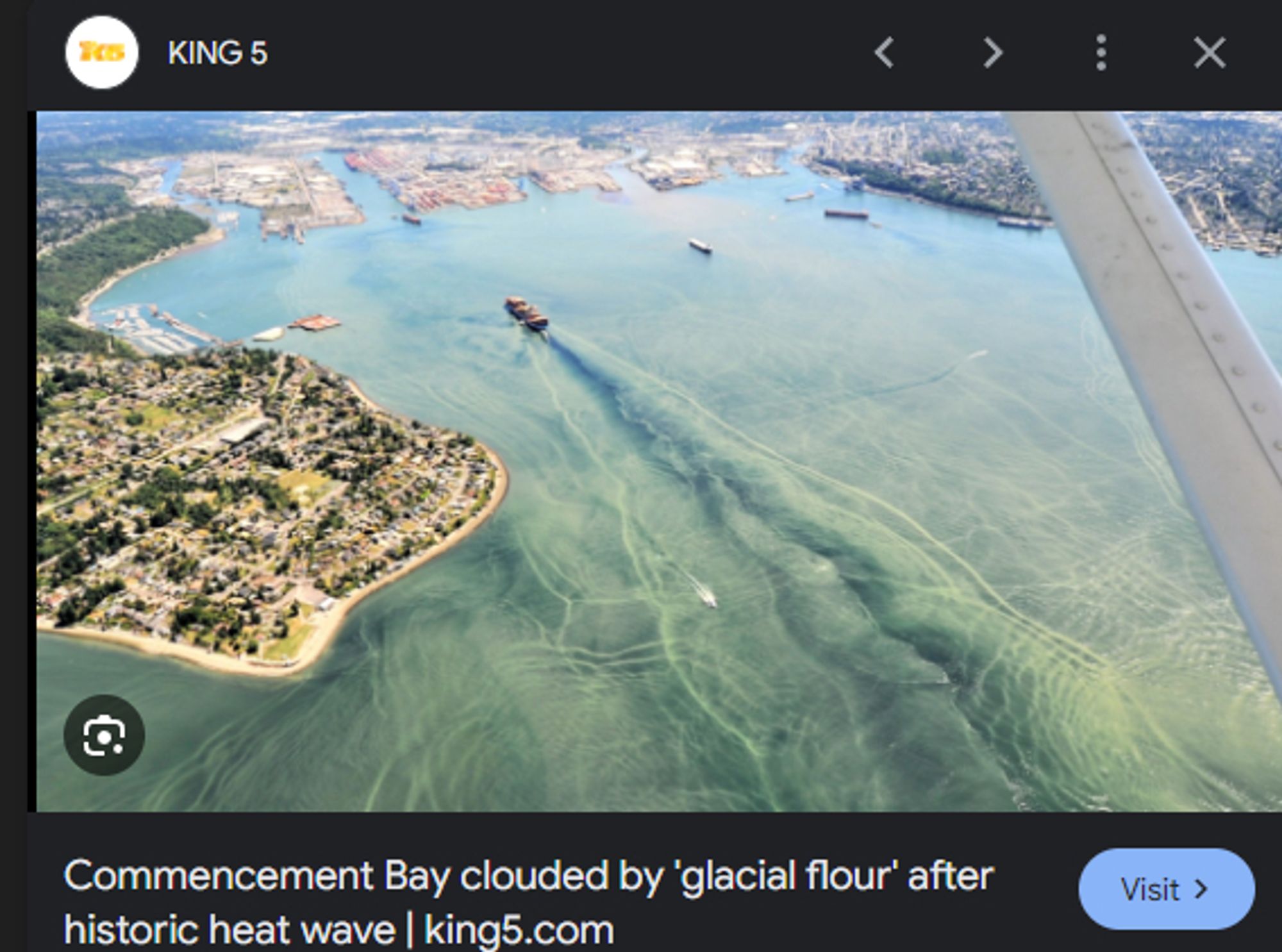 A photograph of tacoma's commencement bay, the place where all the old rail lines ended up, with the caption "Commencement Bay clouded by 'glacial flour' after historic heat wave"