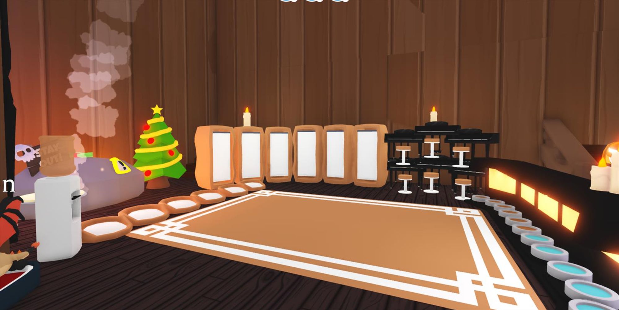 This cozy, fall-themed Roblox Adopt Me house features warm wooden walls, glowing candles, and a festive Christmas tree. A steaming hot tub with a "STAY OUT!" sign adds a playful touch. Framed panels and circular rugs lead toward the center of the room, creating a pathway. On the right, stools sit near counters for a cozy seating area. The room's soft lighting, rustic furniture, and holiday decor create a warm and festive atmosphere, perfect for fall and winter.