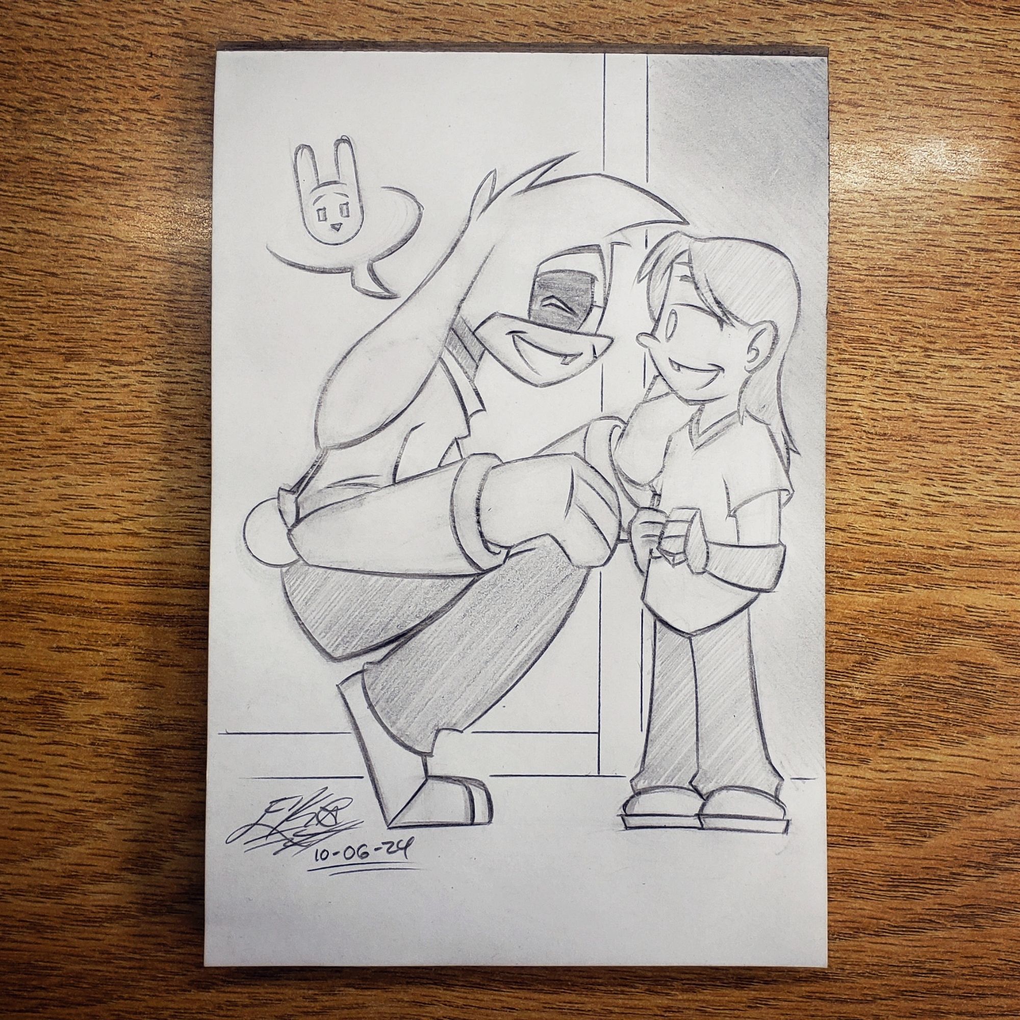 Photo of a traditional pencil pic. Lucas, a human in an anthro Bunny Bot body, squats down to meet with his newest patient. She's a young girl with a prosthetic hand and forearm. She's surprised to see that her prosthetists is a big robotic doggy. Lucas places a big ol' hand on her shoulder, smiles and explains he's a really big rabbit.