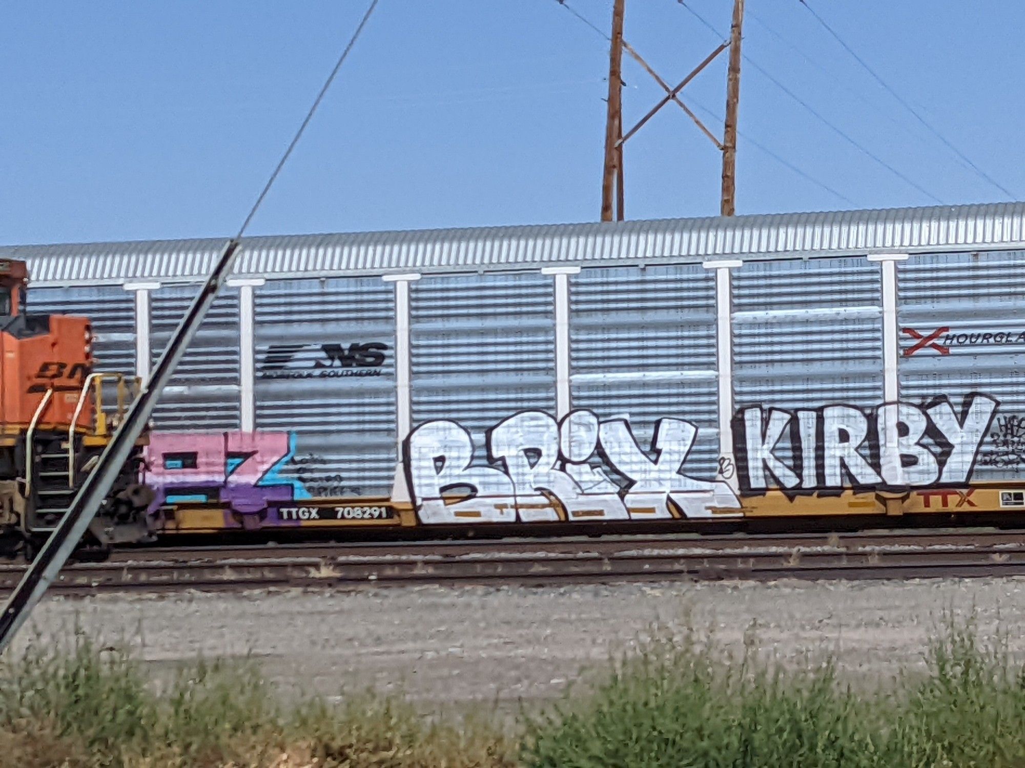 Picture of a silver train car with "Brix" graffitied on the side in white paint outlined in black