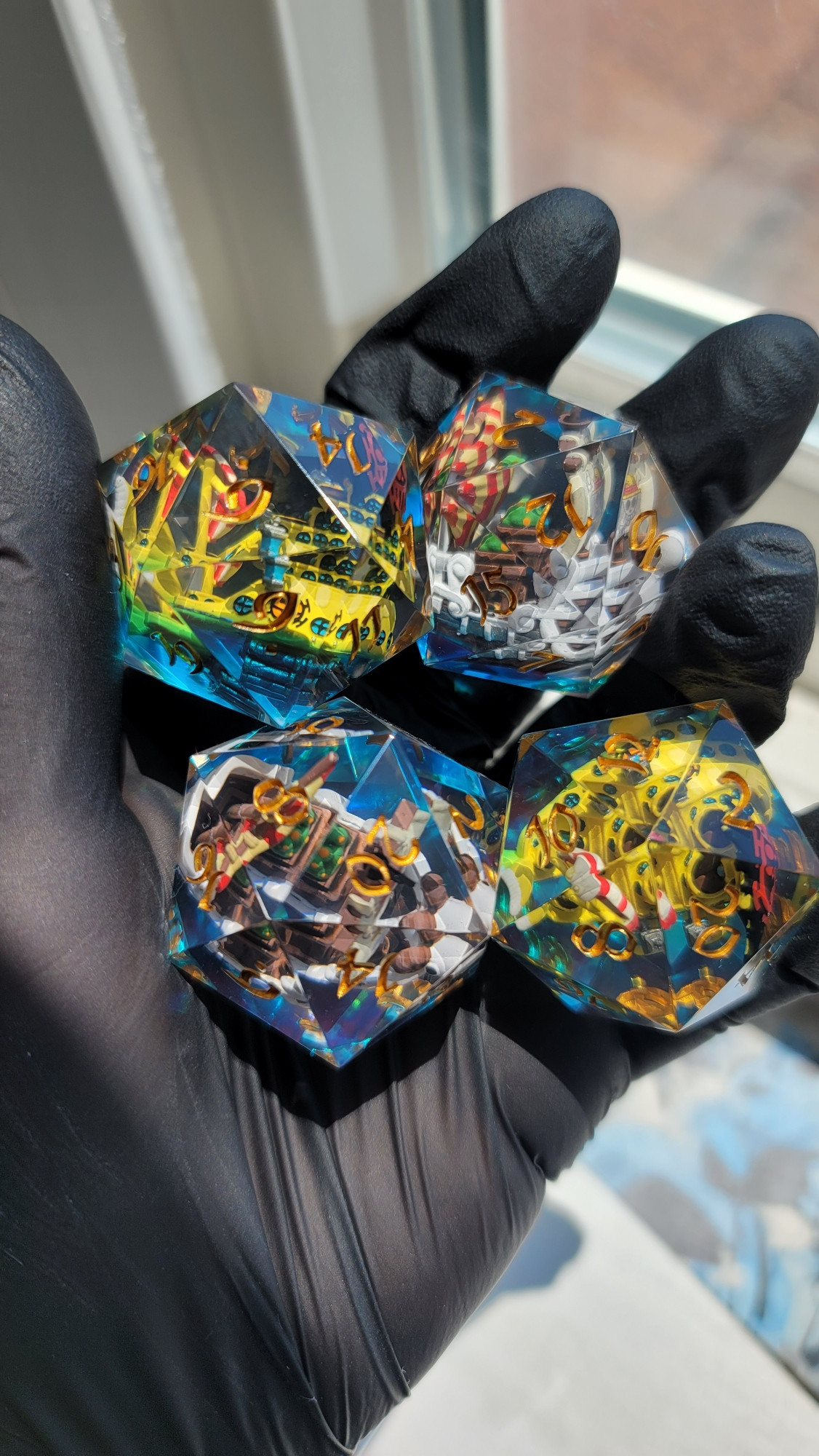 Four handmade 32mm D20s. Two with a handpainted Going Merry inclusions and two with handpainted Polar Tang inclusions. Polished up and painted with gold ink.