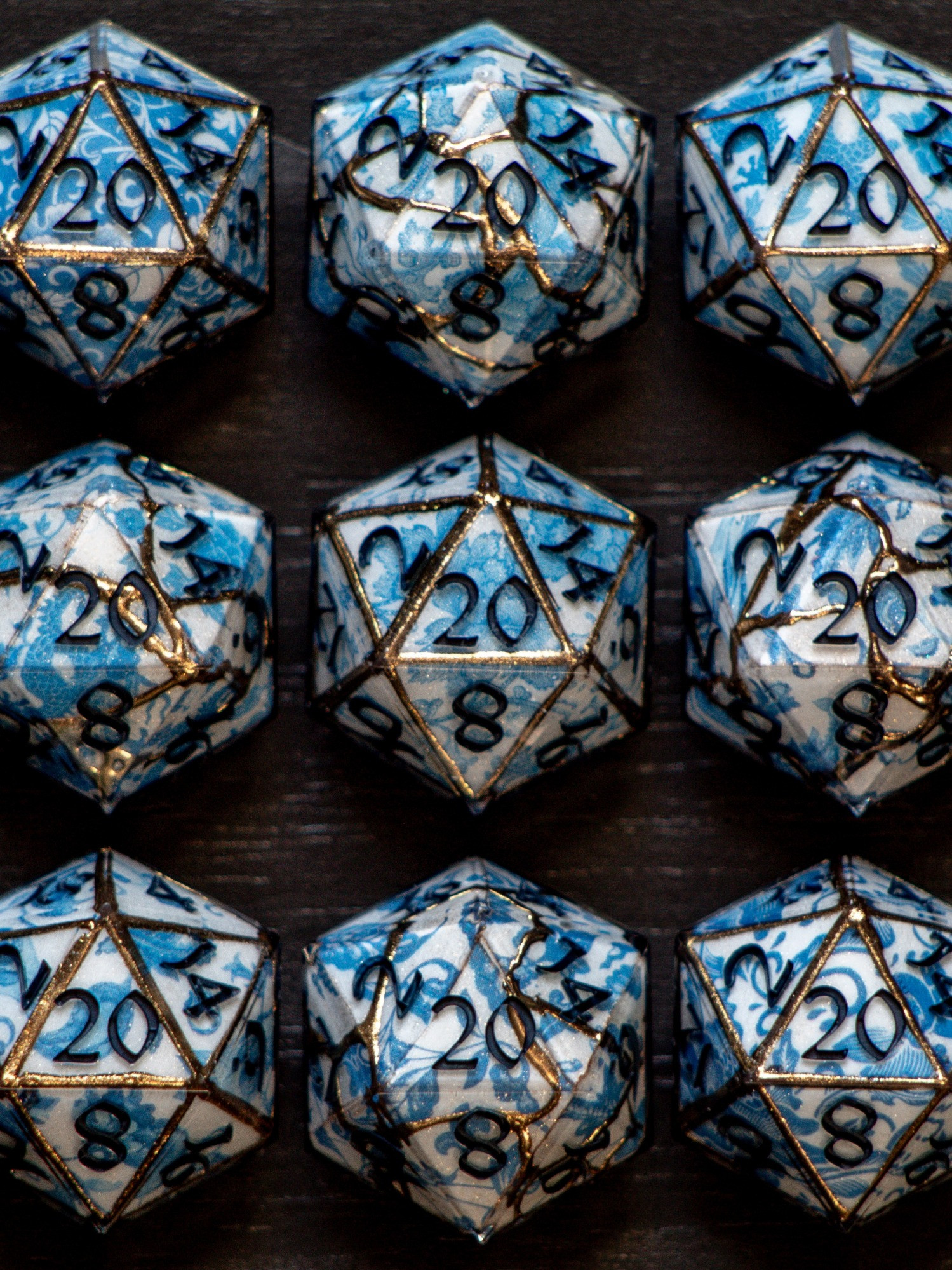 Handmade D20s painted to look like gilded porcelain. 