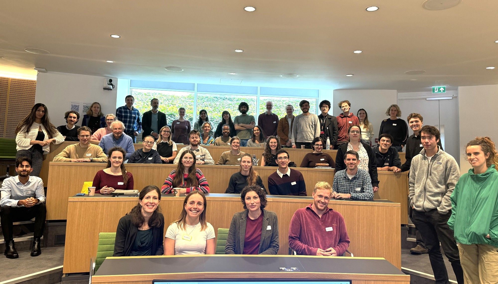 A group of researchers pose for a group shot in a small lecture hall