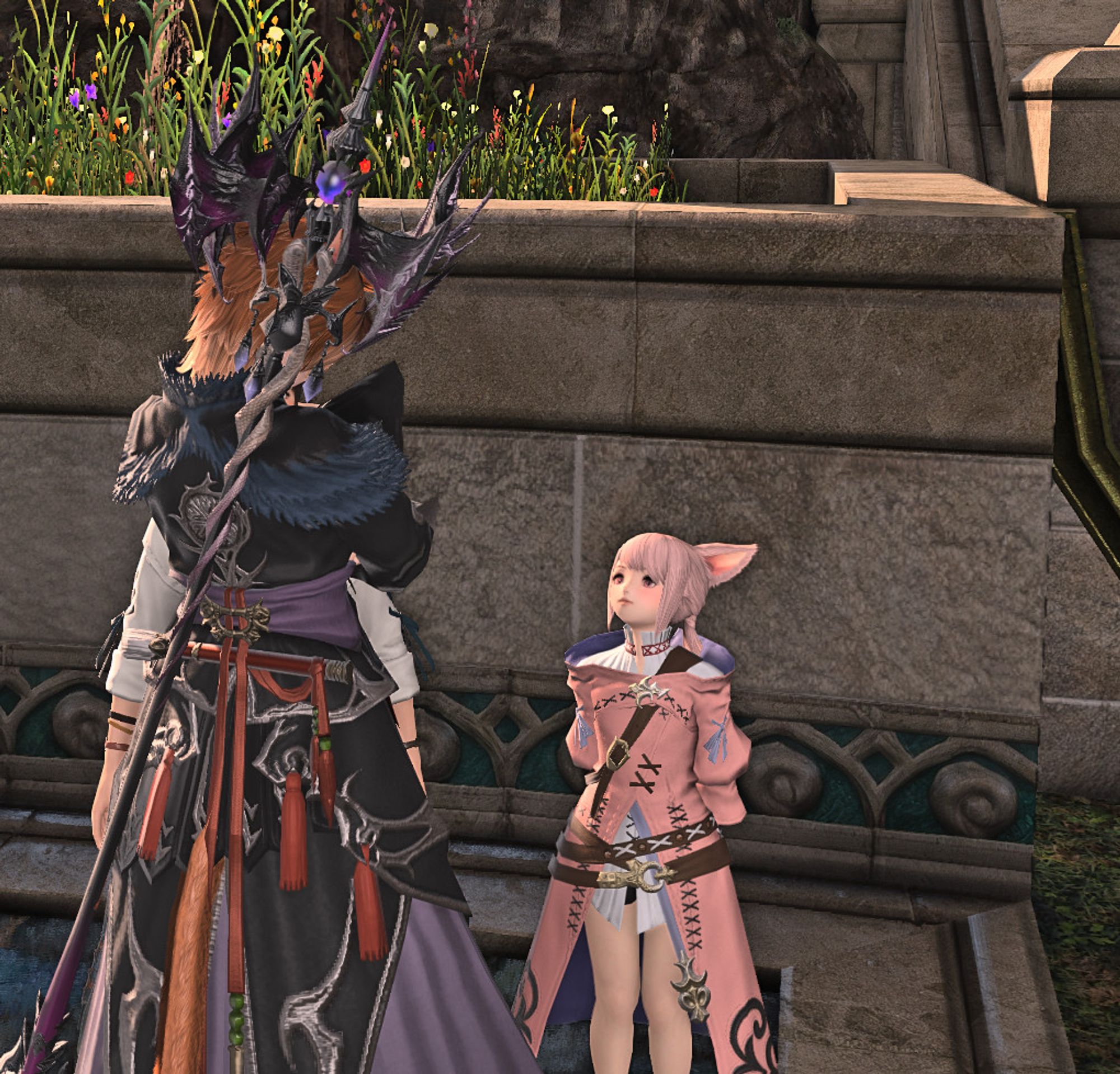 A Final Fantasy 14 catgirl looking down at a pink haired catgirl child in a pink robe, who is looking up at her.