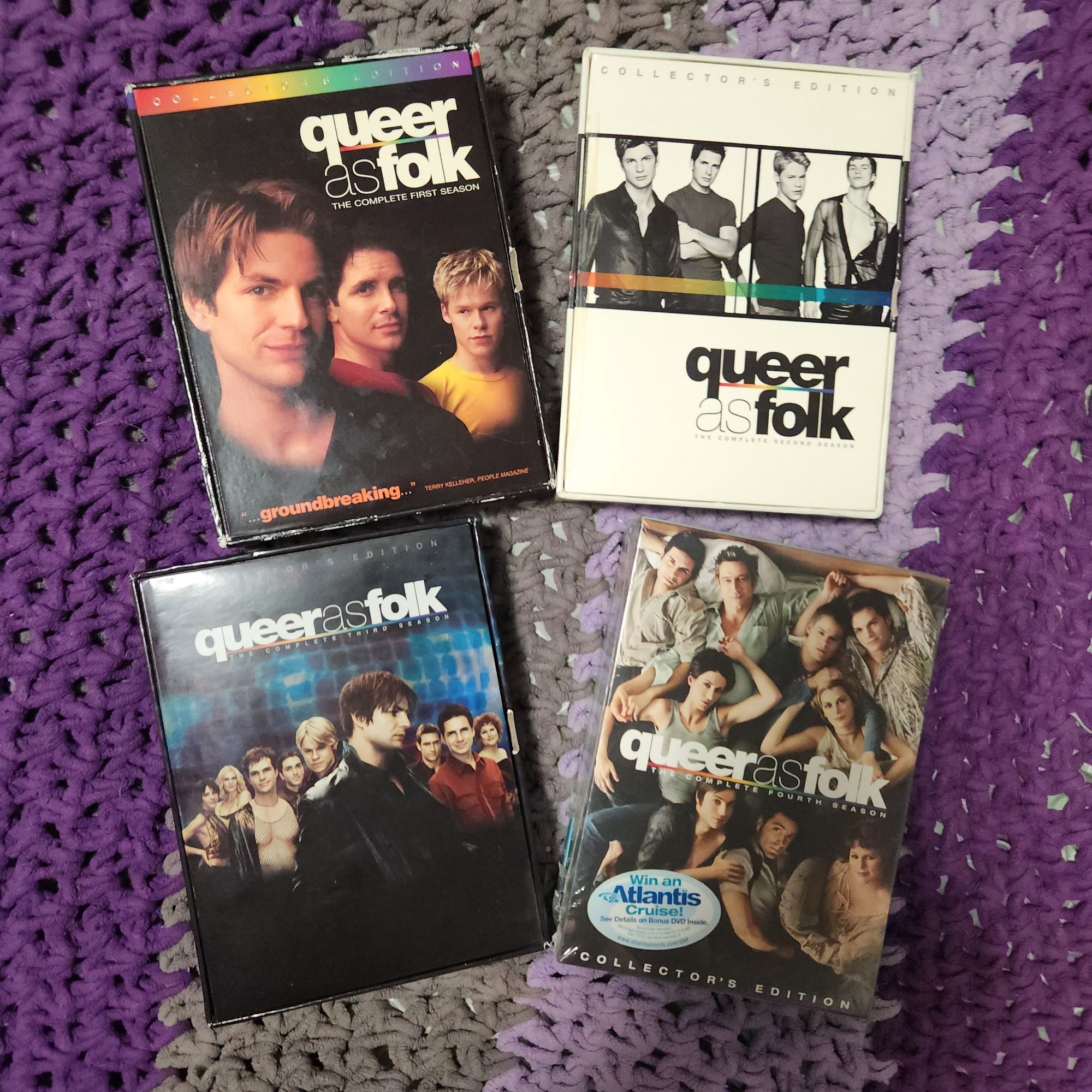 photo of box sets seasons 1 to 4 of queer as folk, purple, lilac, gray blanket background