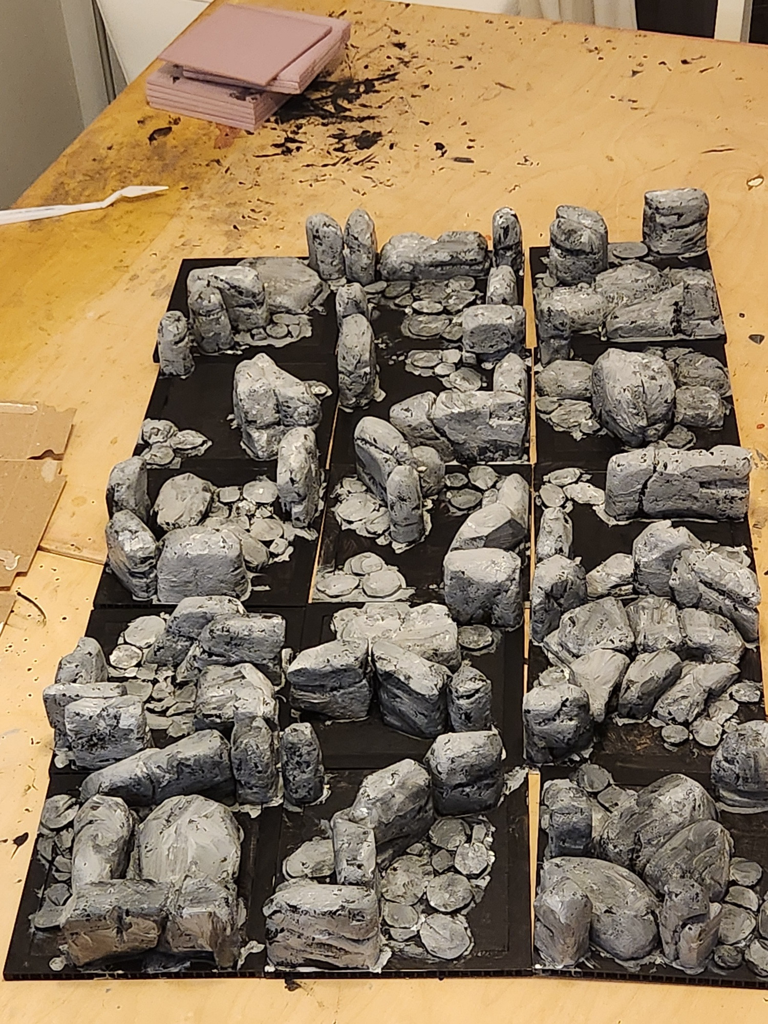 Photo of the board under construction. Each of the tiles is 6"x6" and has carved foam glued on top. The foam has been painted grey