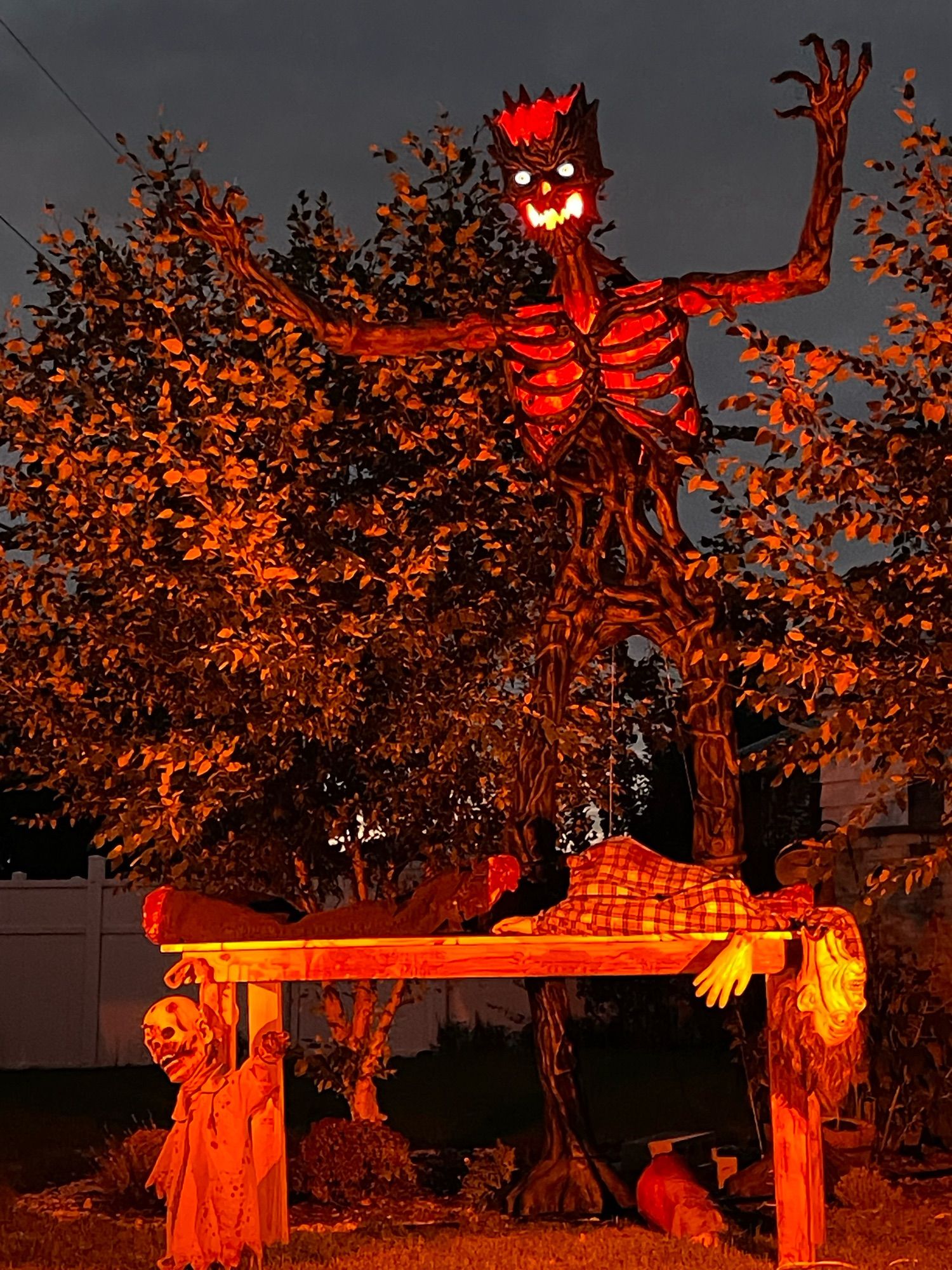 A 12-foot Ent  with orange eyes and a jack-o’-lantern face stands menacingly over a sacrifice.