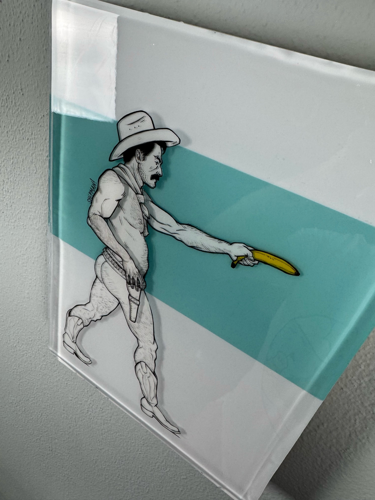 A mixed media resin and acrylic painting. There’s a cowboy facing to the right, left arm outstretched holding a banana. The cowboy is wearing a hat, boots and a belt. Behind him is a horizontal rectangle of Tiffany blue resin.