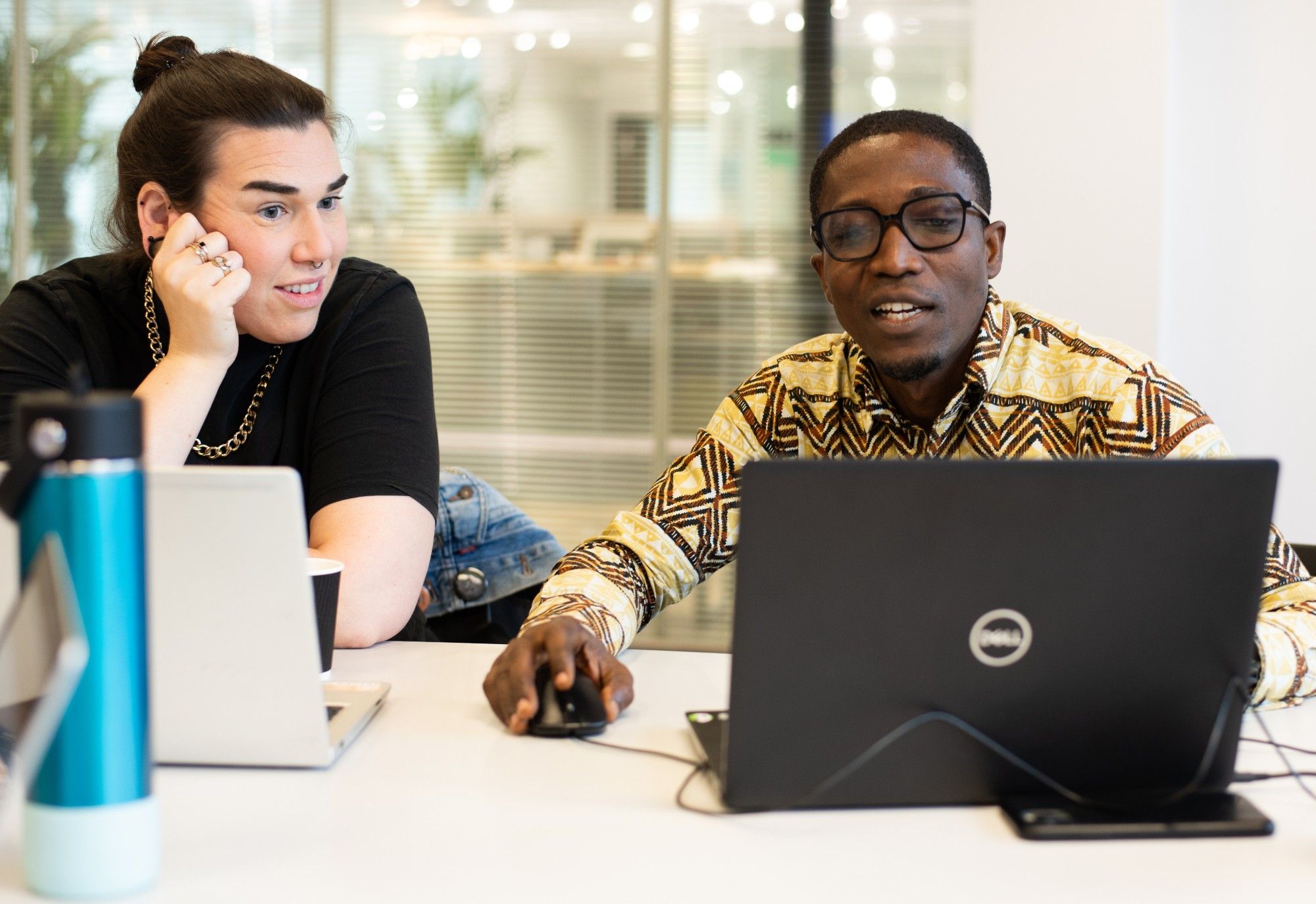 Dr Daniel Kumah working with Catherine Robins at the Heritage Jam. They are both looking at a computer screen and Daniel is discussing what is on the screen.