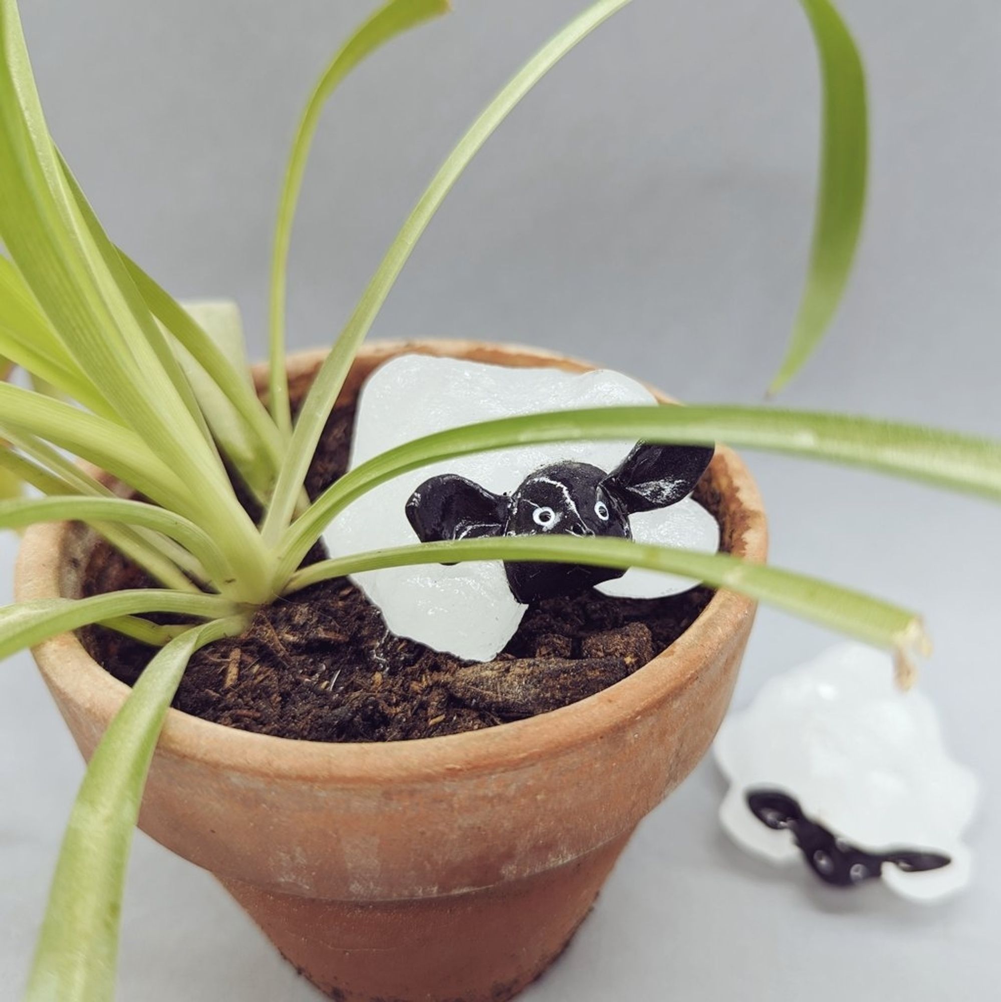 Petit mouton en verre et resine dans un pot de fleur