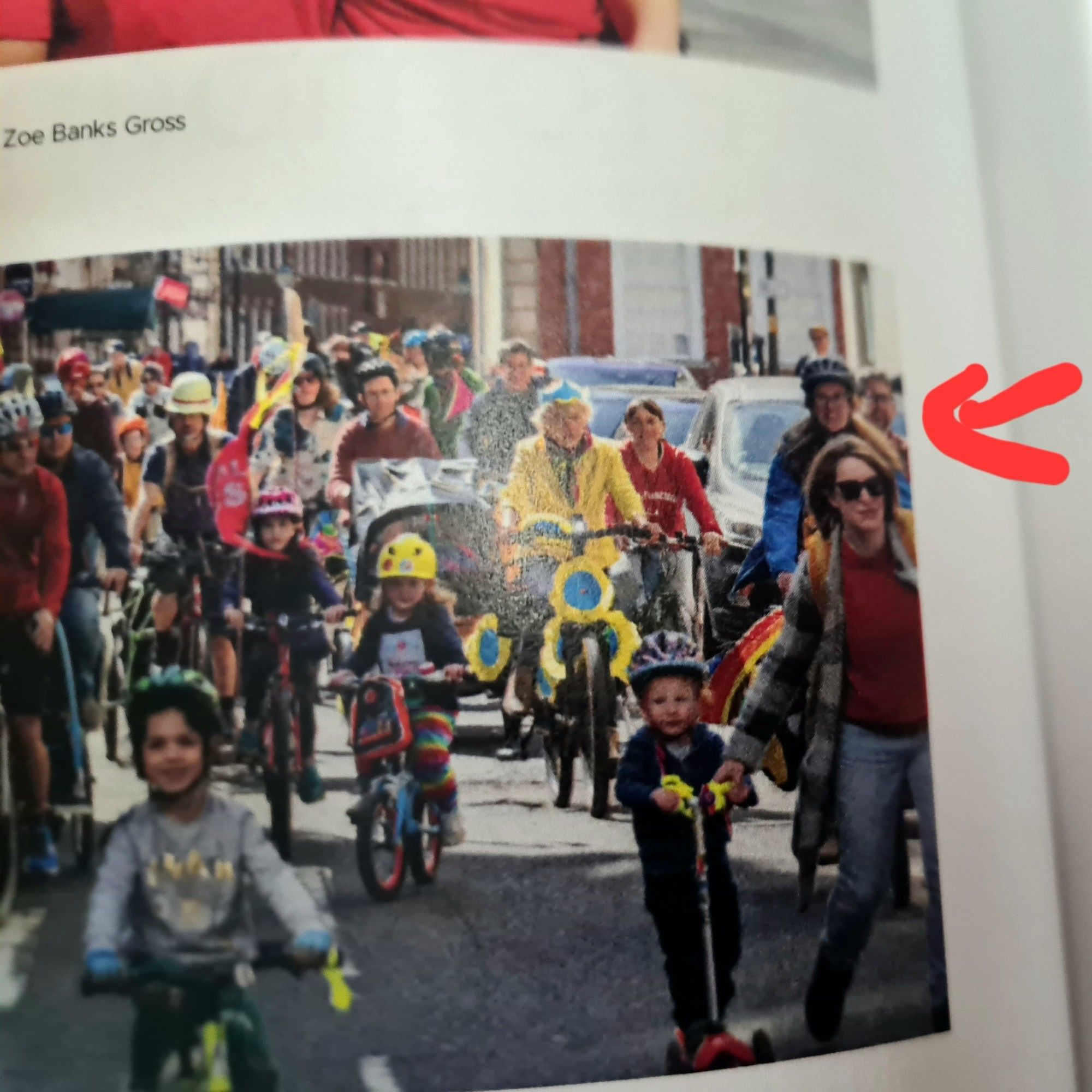 A red arrow points to a very blurry picture of  me cycling within a Kidical Mass bike ride in Bristol city centre.