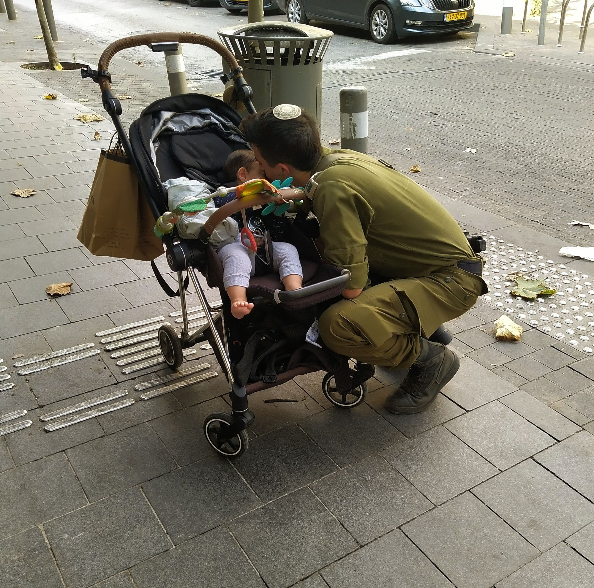 Young soldier kissing his 7 month old child goodbye