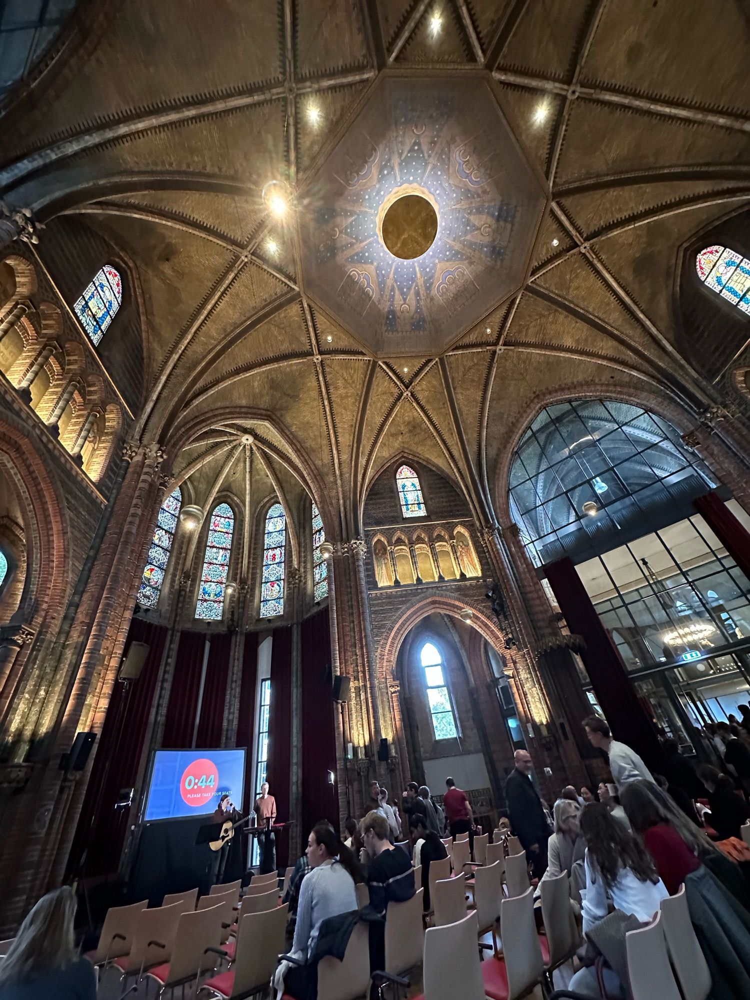 Interior of Vondelkerk, looking up at the ceiling with projection screen visible in the lower left, less than a minute before the service starts.