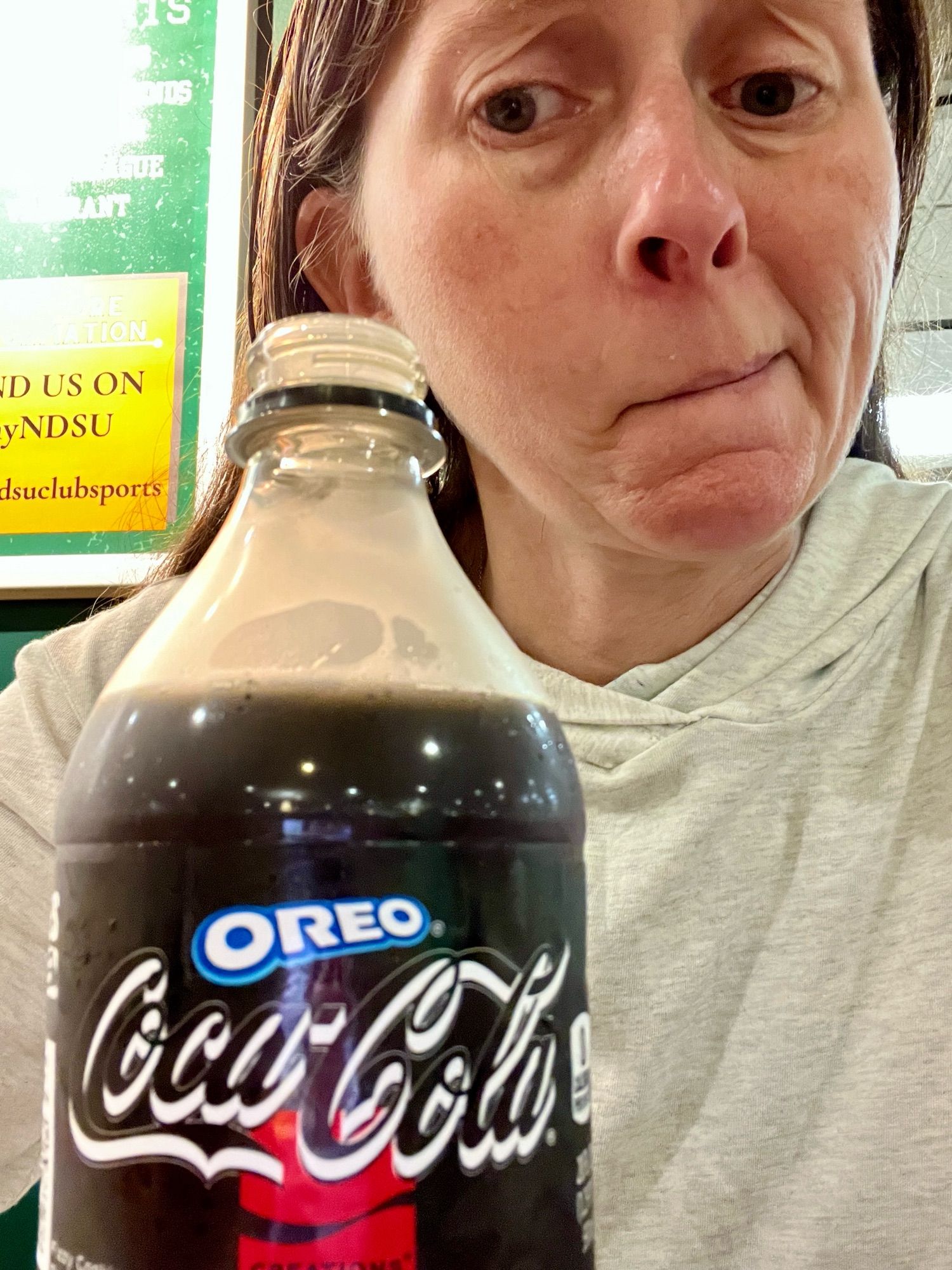 Jenni looking skeptical at a bottle of Oreo flavored Coke Zero.