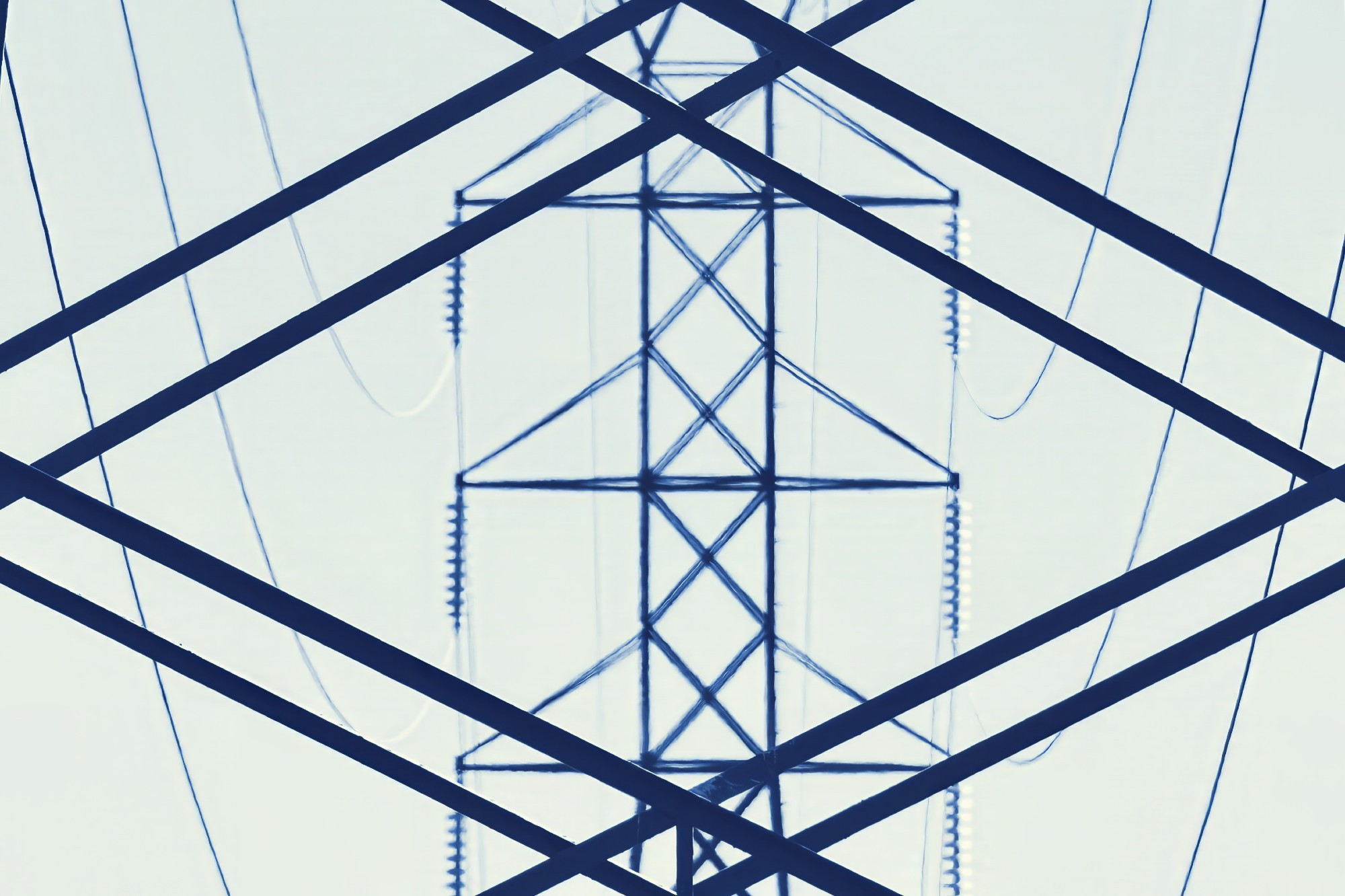 A blue-tinted monochrome image of the pattern of lines seen looking through the rails of a transmission tower at a more distant tower.