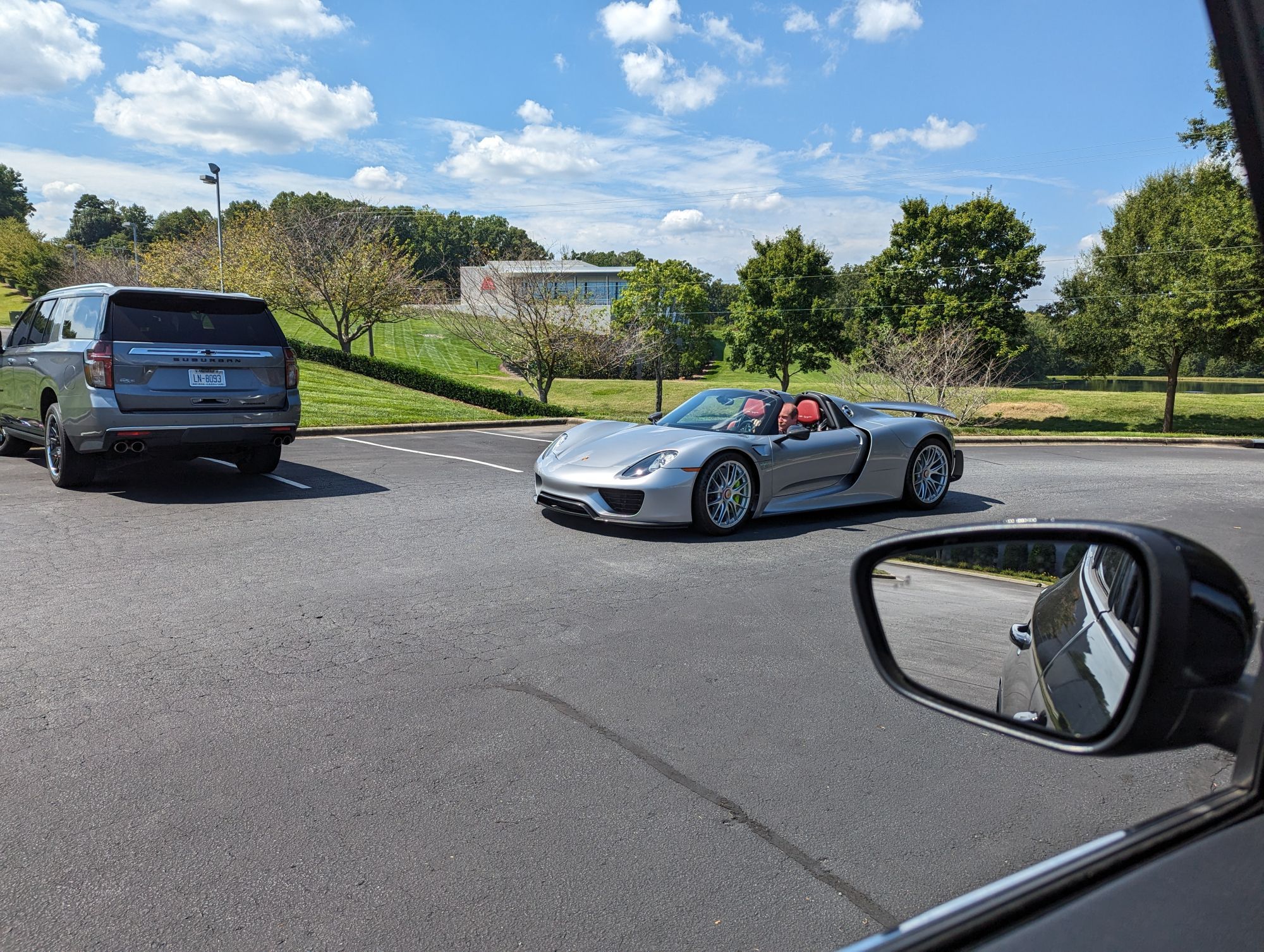 A silver Porsche 918 with red interior.