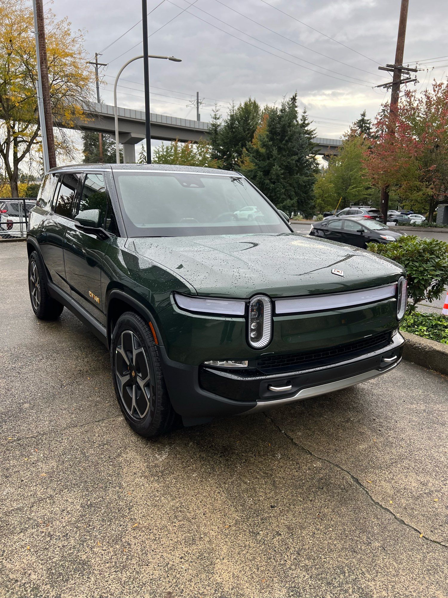 A forest green Rivian SUV model named R1S.