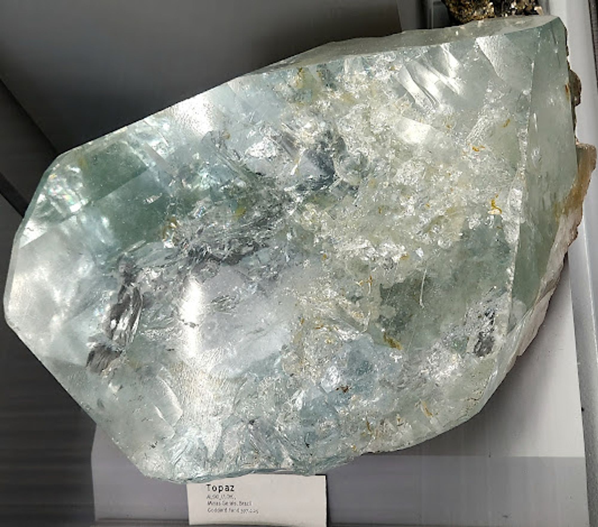 Large slightly bluish-green topaz crystal that has internal flaws and some bumps.