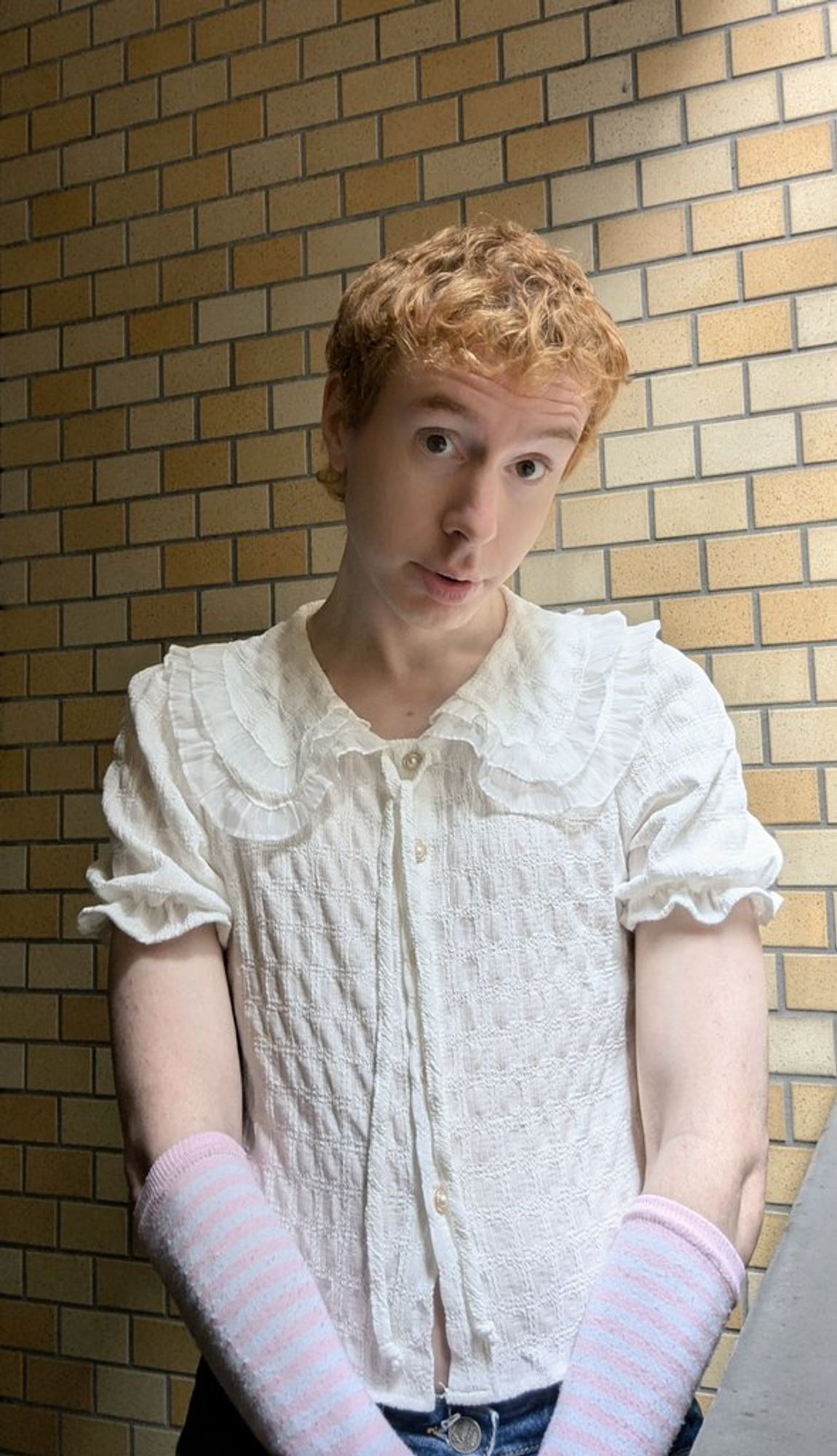 Femboy wears ruffled lace top and pink arm warmers