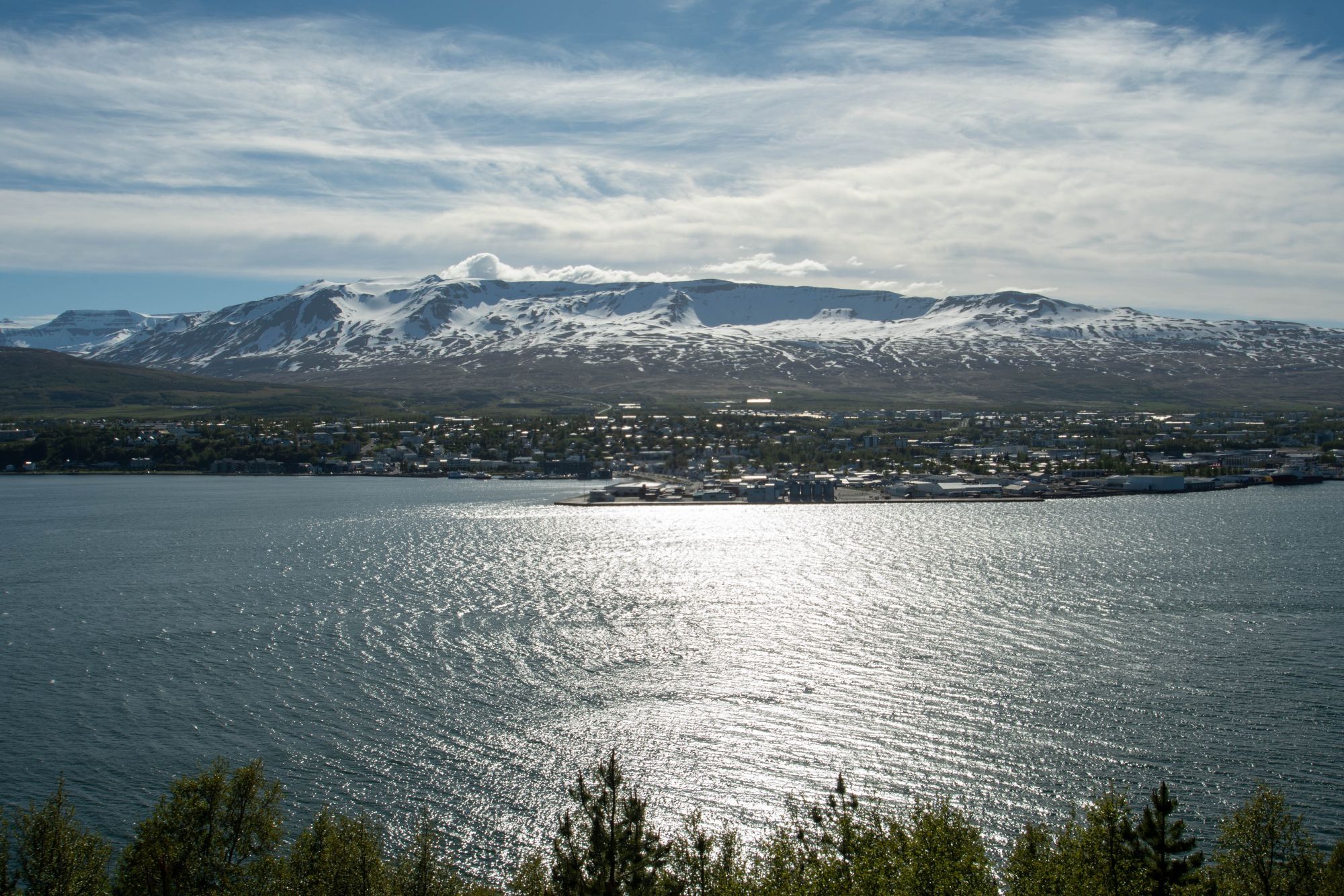 large bay with town and snowy mountains on the other side