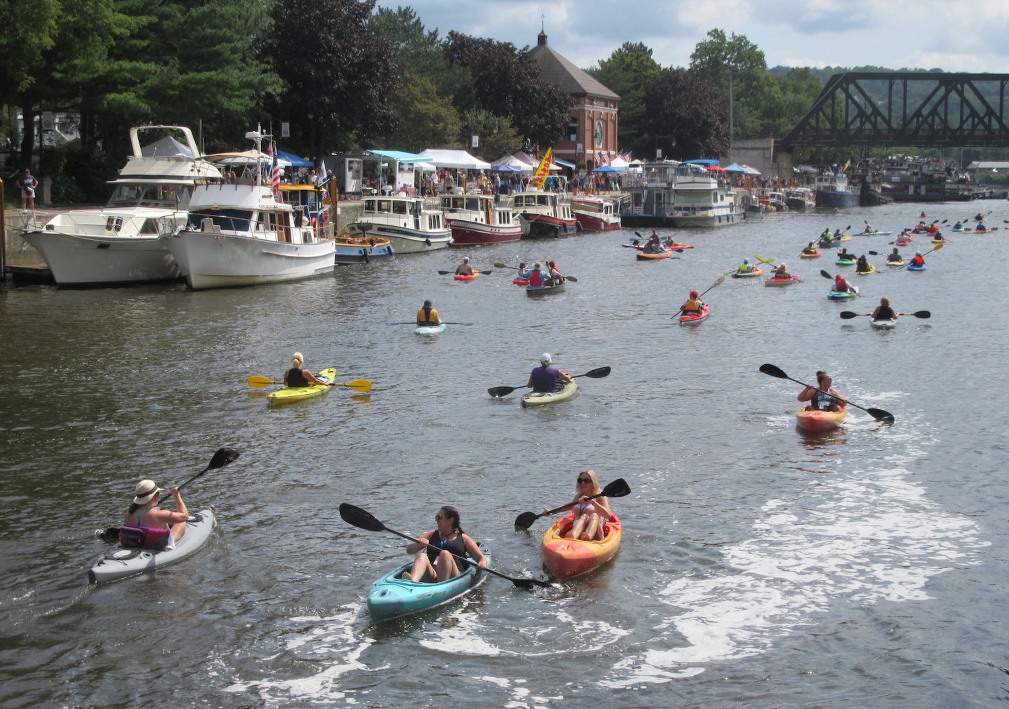 Kayaks on the water with tugboats in distance