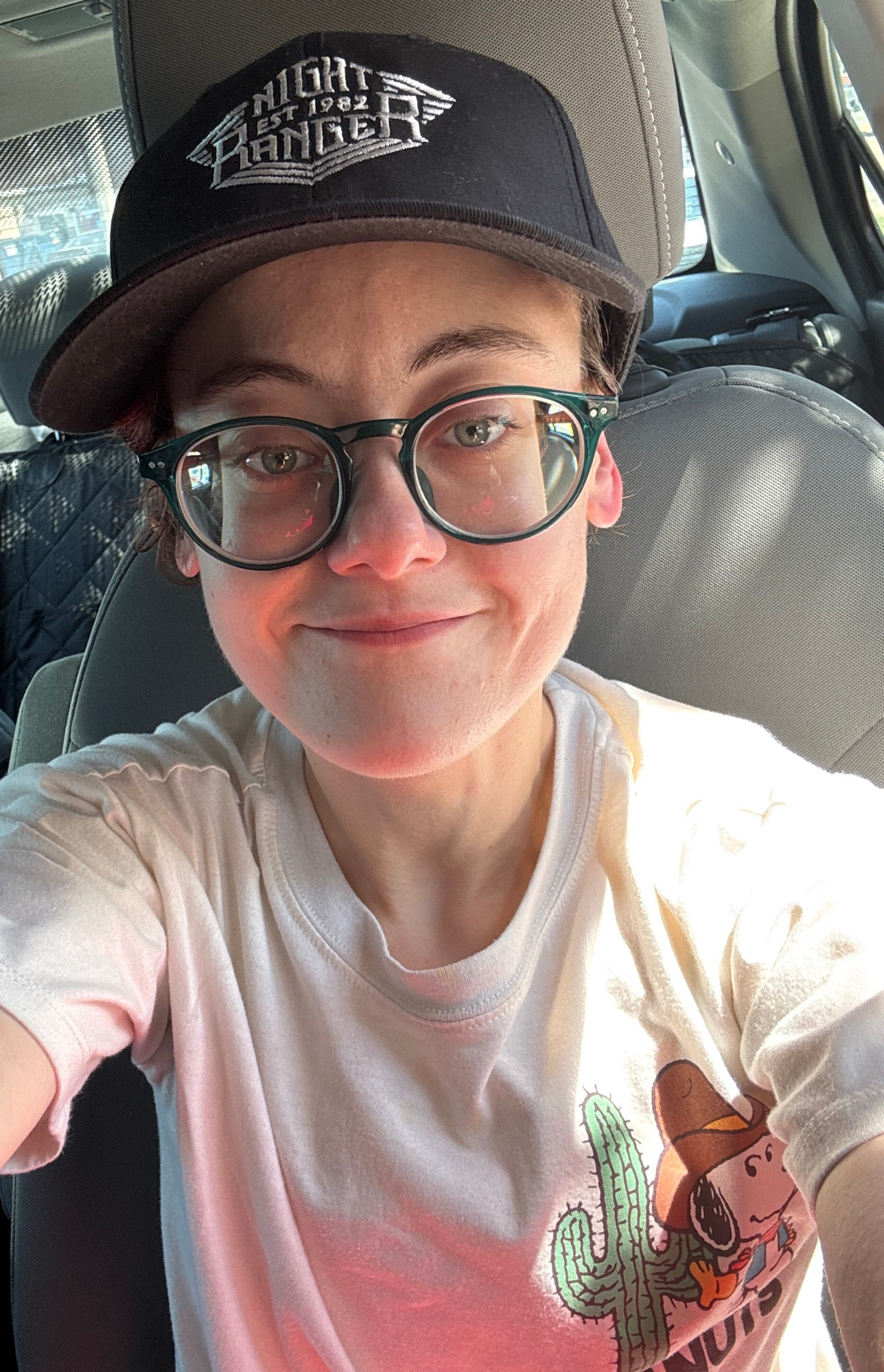 A young person takes a selfie in a black Night Ranger hat