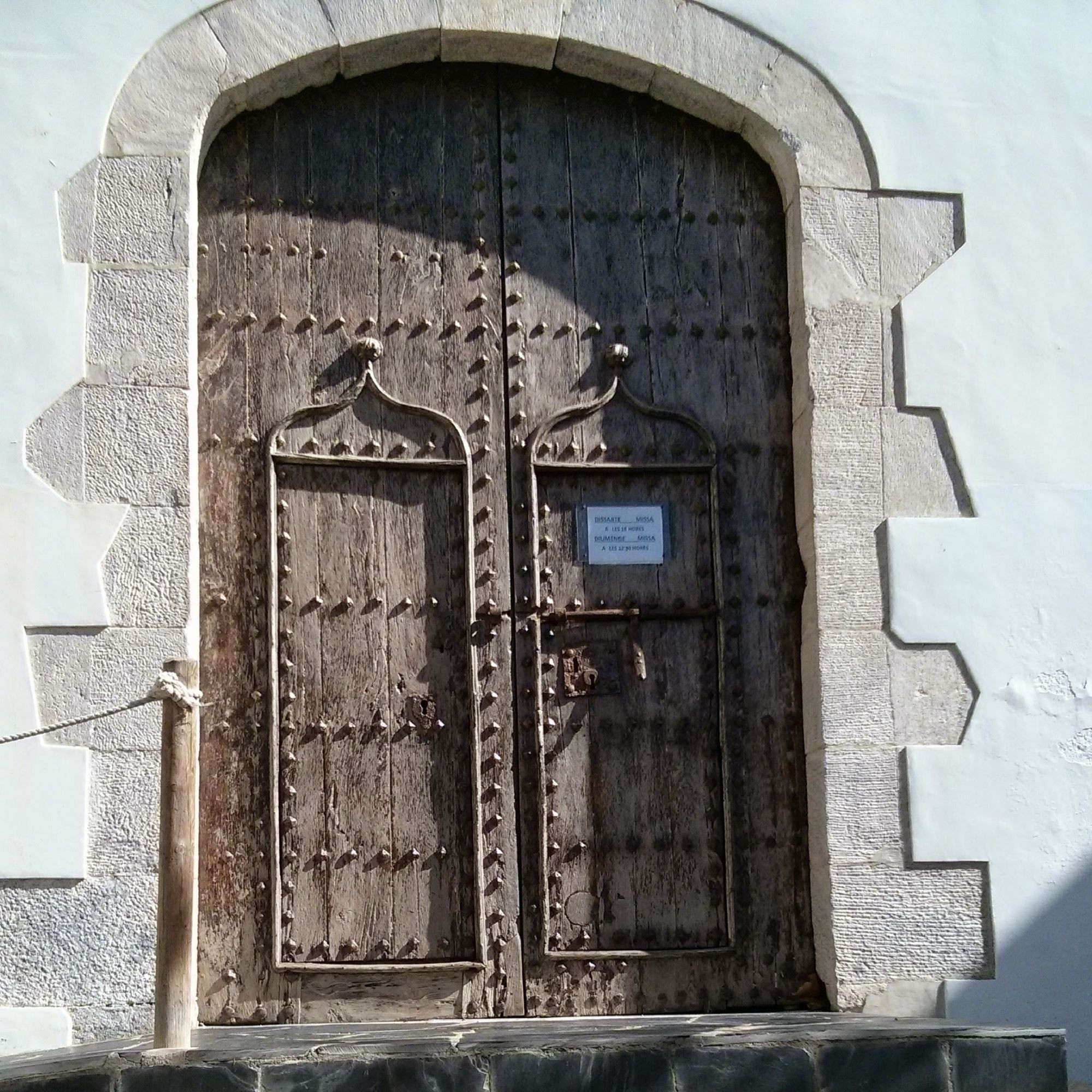 Double wooden church doors in catalonia with traditional visible bolts