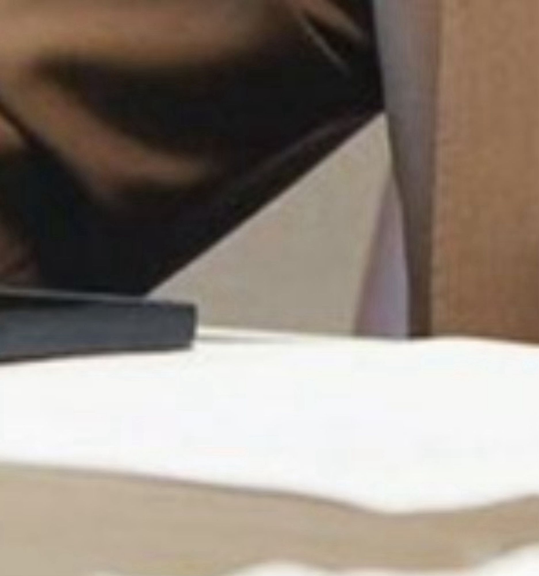 Kamala’s phone laying flat with a protruding shadow next to it exactly where a usb to 1/8” audio dongle would be plugged in