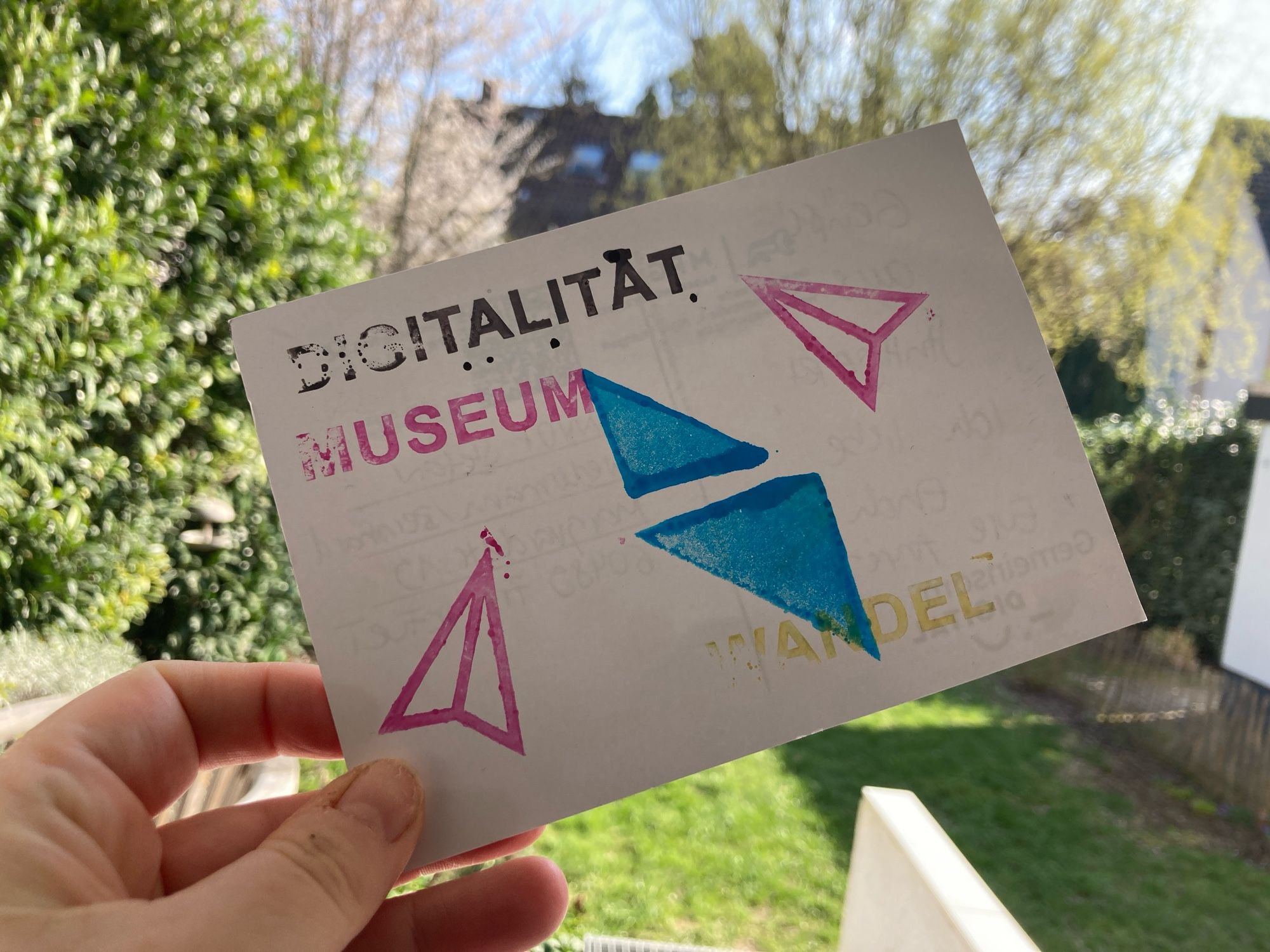 Postkarte auf der grafische Symbole sind und die Worte Digitalität Museum und Wandel gestempelt bunt