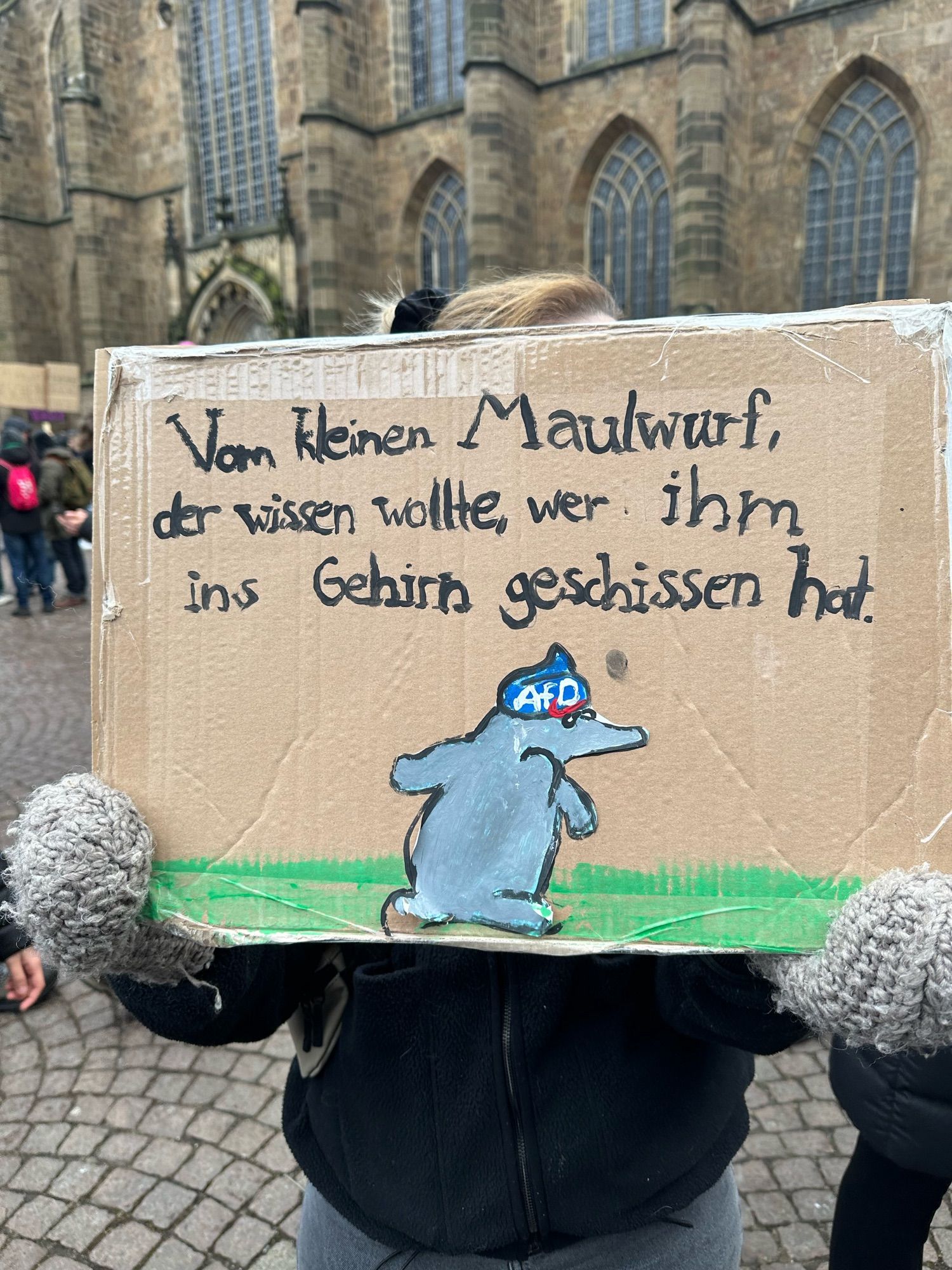 Demoplakat mit einem Bild vom kleinen Maulwurf mit einem blauen Kackhaufen auf dem Kopf auf dem AfD steht